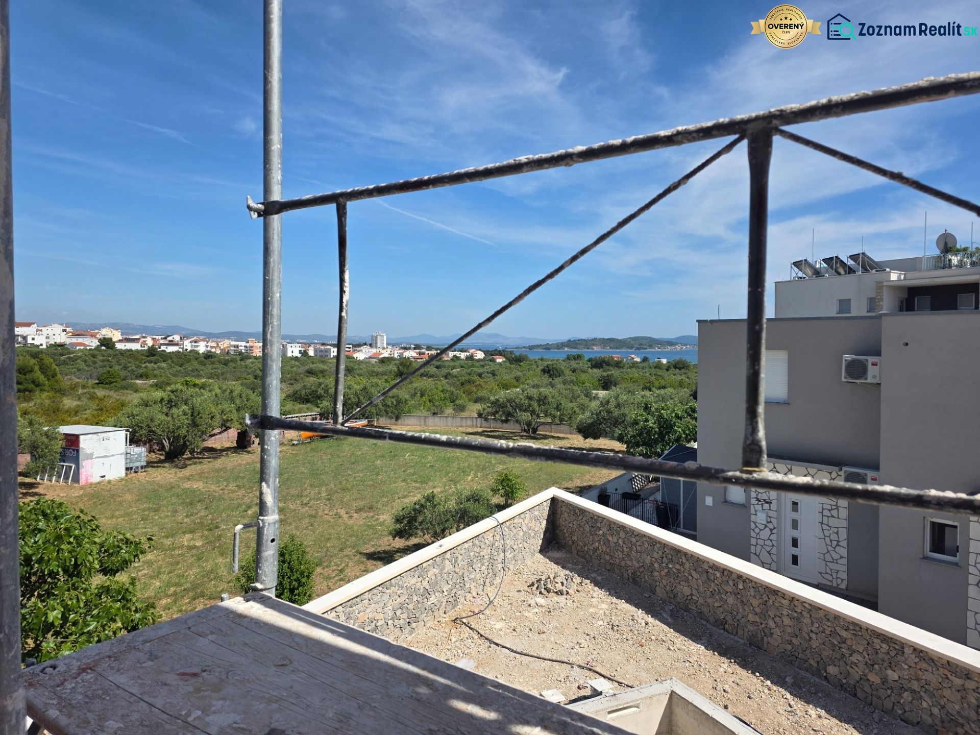 Der Ausblick aus der 3-Zimmer-Wohnung in TRIBUNJ zeigt eine Baustelle und ein Panorama mit Meer.