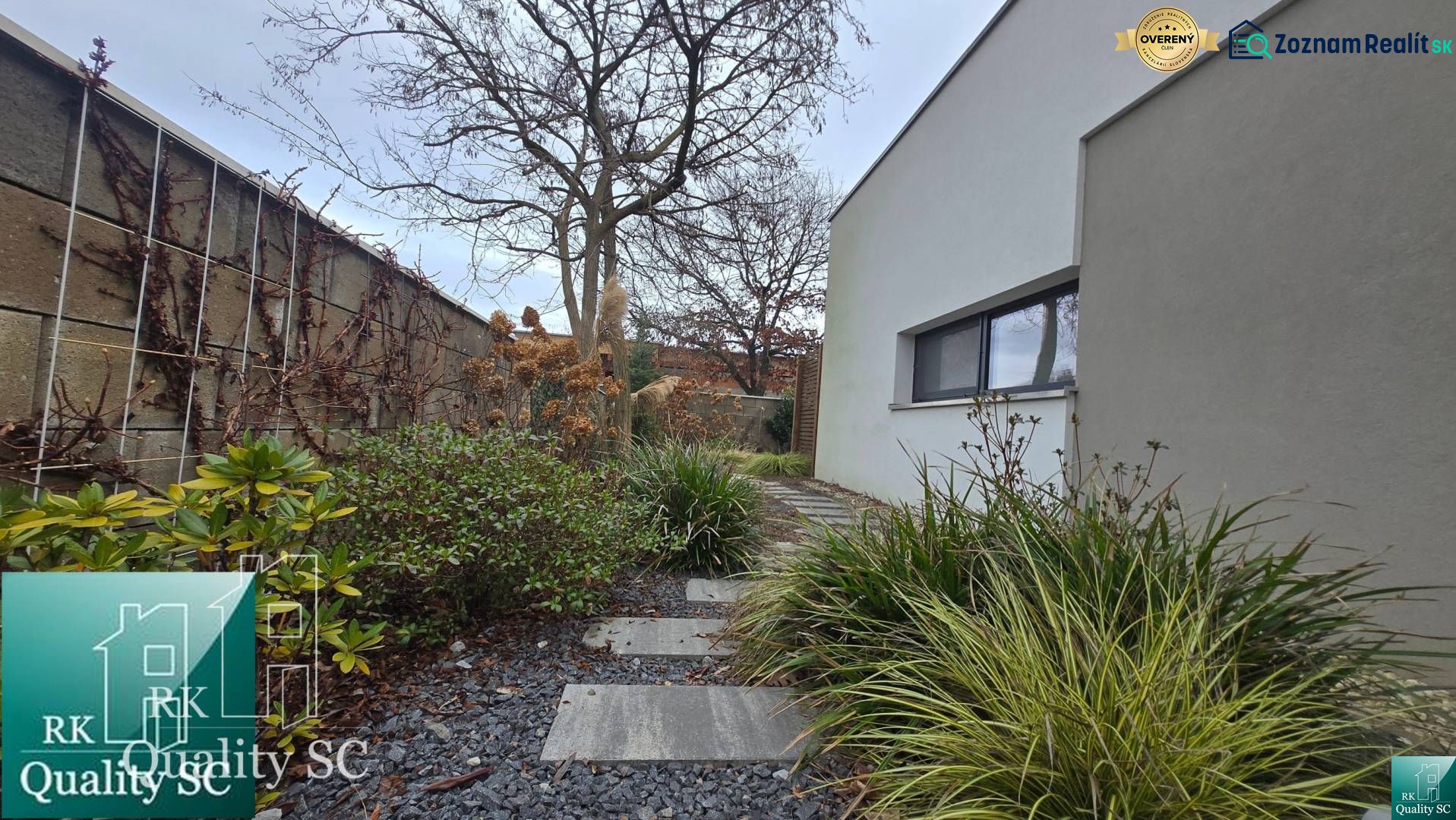 Ein Einfamilienhaus in Senec mit einem gepflegten Gartenweg, verziert mit Kieselsteinen und grünen Pflanzen.