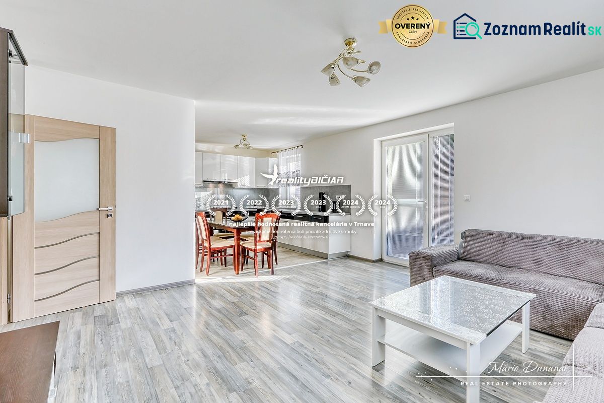 Innenraum eines Einfamilienhauses mit offener Küche und Wohnzimmer, Boden mit Holzdekor.