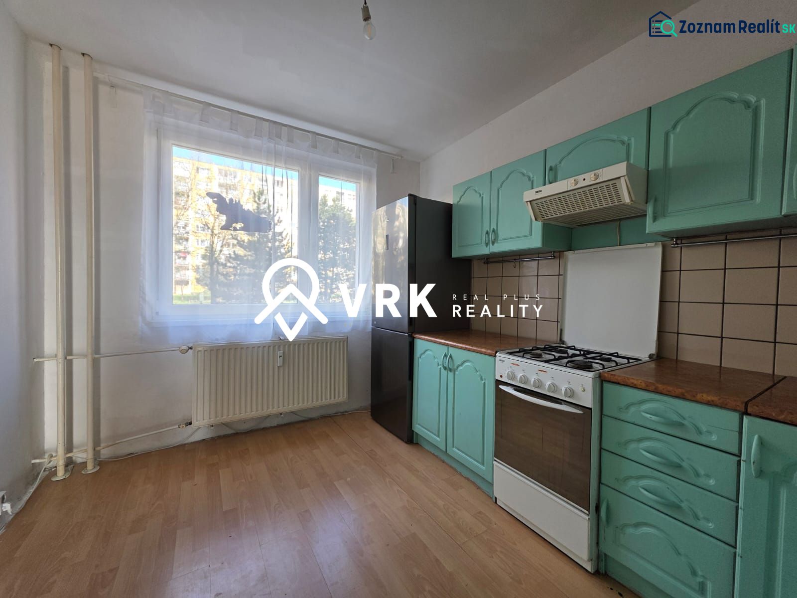 Küche mit Gasherd, grünen Schränken und Holzboden in einer 4-Zimmer-Wohnung.
