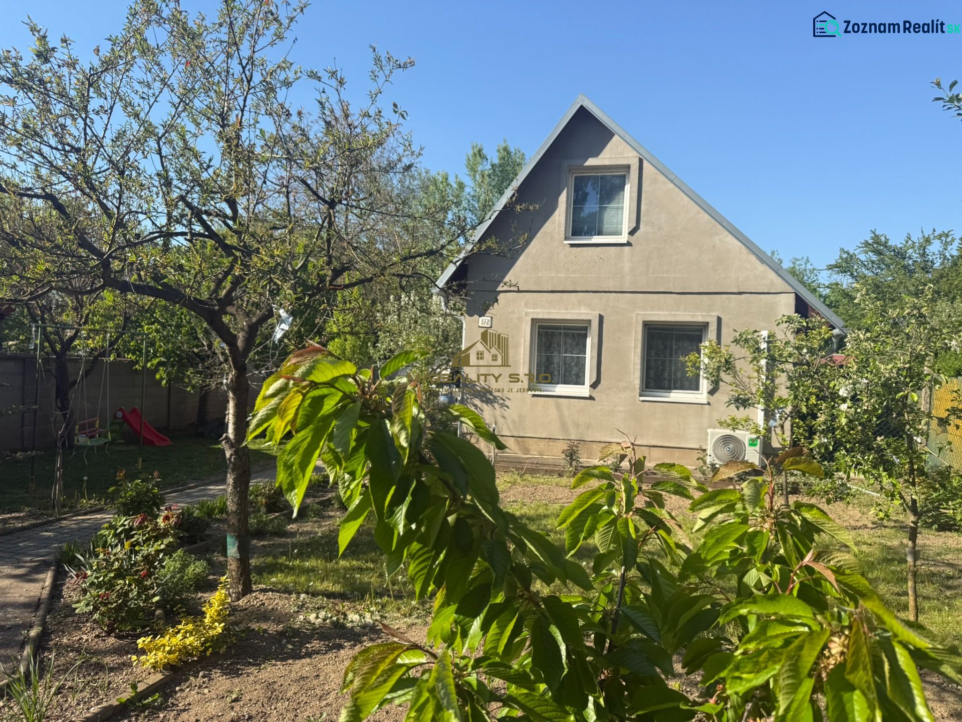 Ein Ferienhaus im Dorf Sekule in der Straße Sekule, umgeben von einem Garten mit Obstbäumen.
