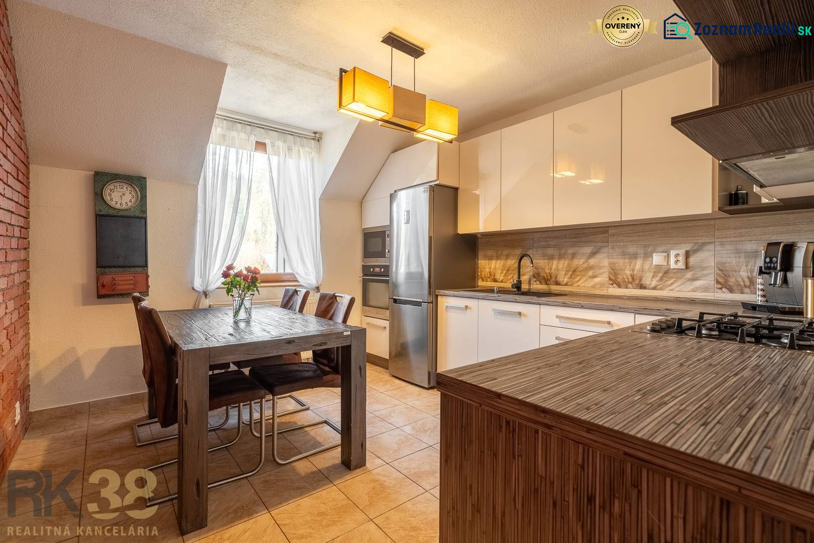 Küche in einer 4-Zimmer-Wohnung mit Esstisch, Kronleuchter und modernen Geräten.