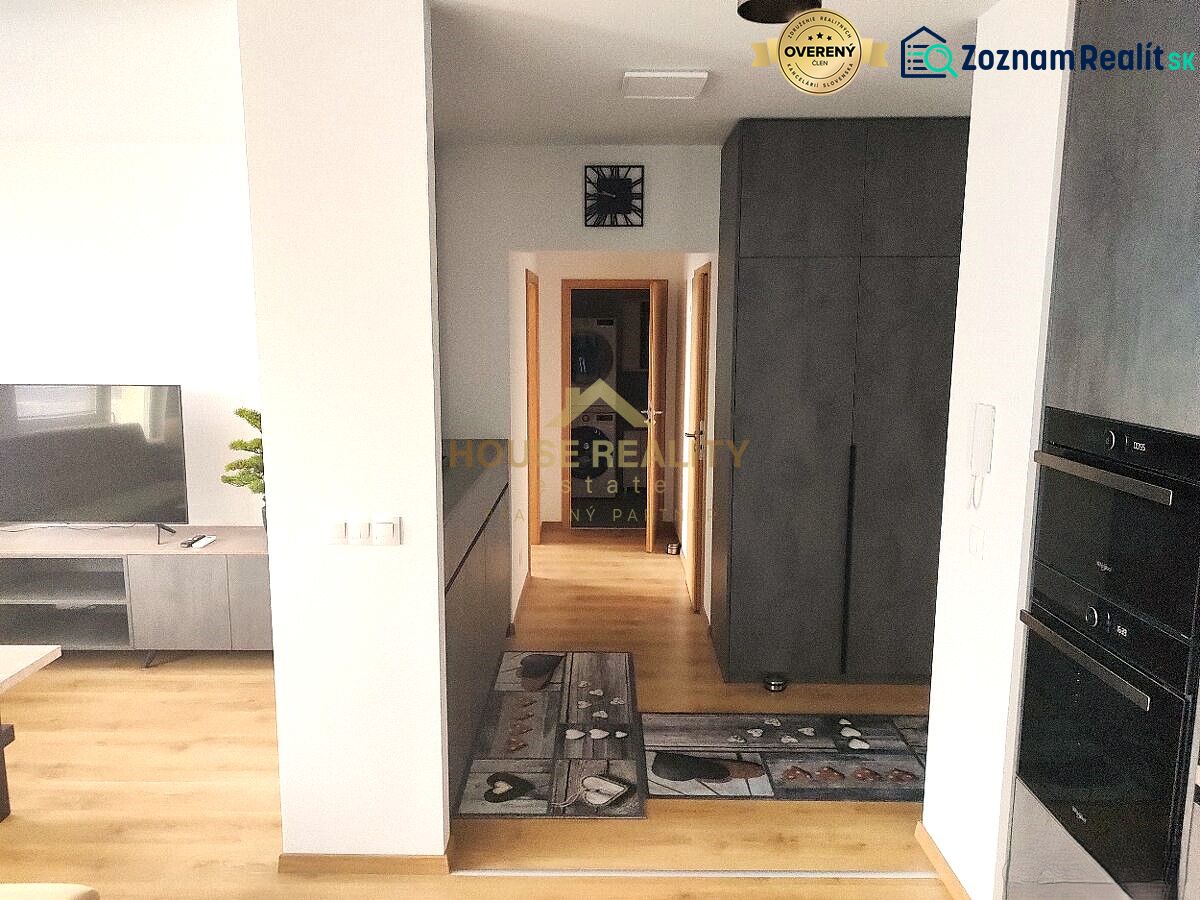 Innenraum einer 2-Zimmer-Wohnung mit Holzboden, Fernseher und Stauraum.