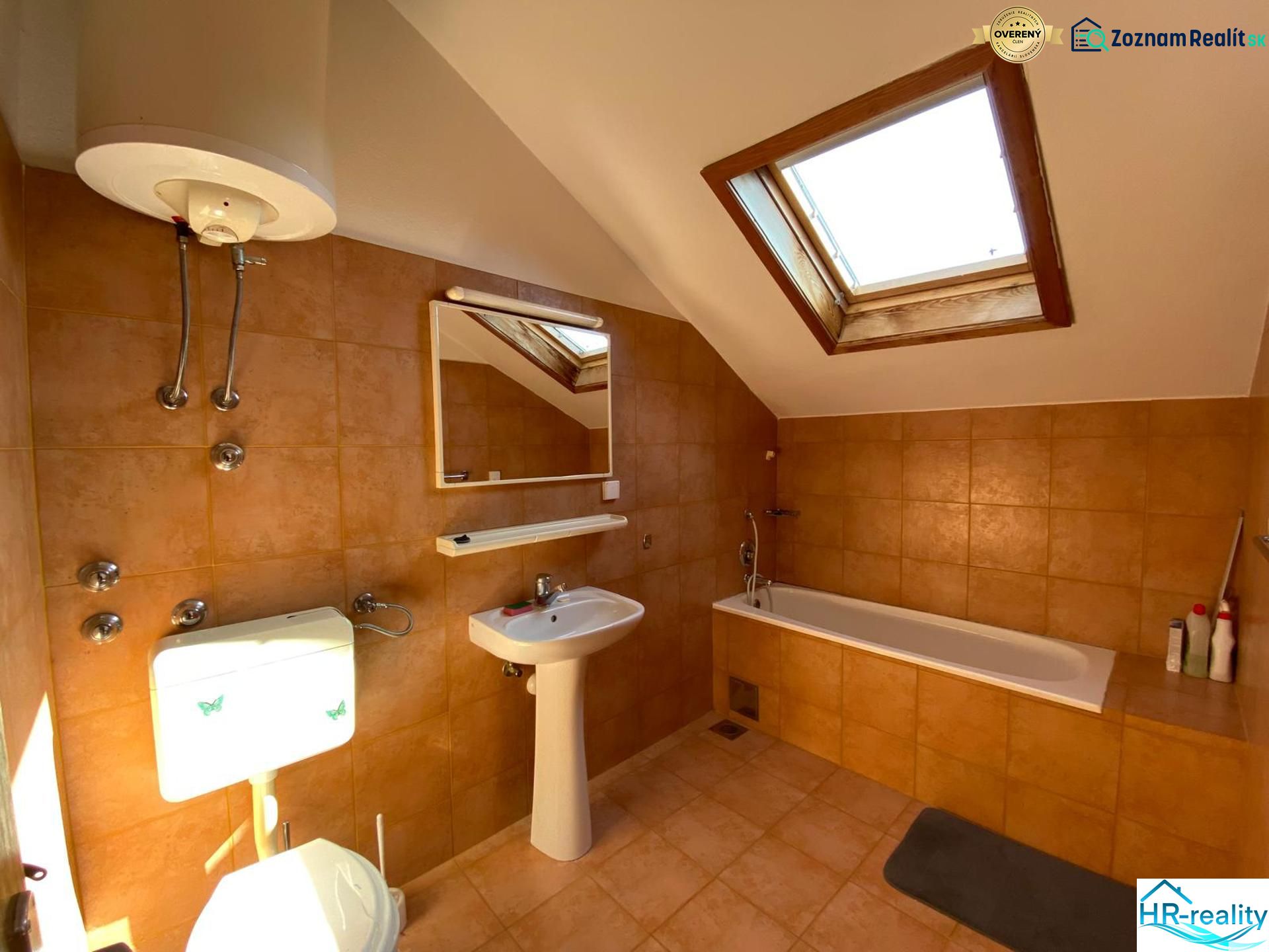 Badezimmer in einer Ferienwohnung mit Badewanne und Dachfenster.