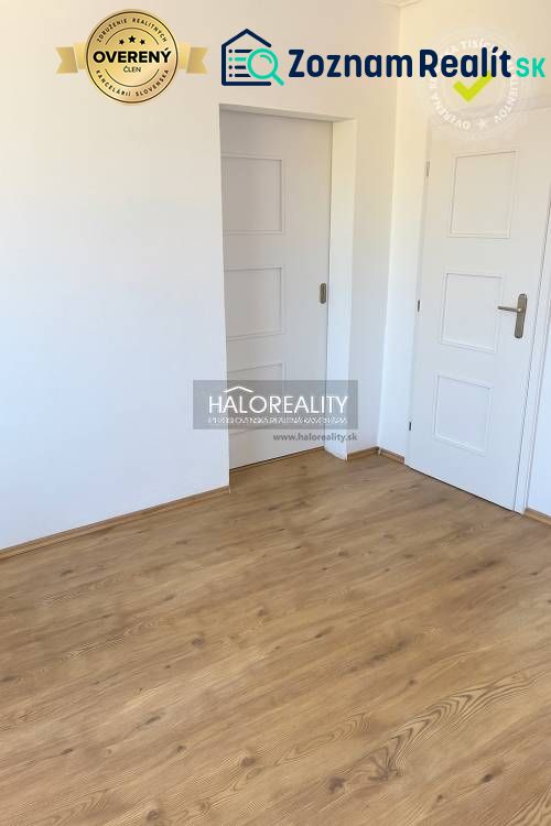 Innenraum eines Einfamilienhauses mit weißen Türen und einem Boden in Holzoptik.