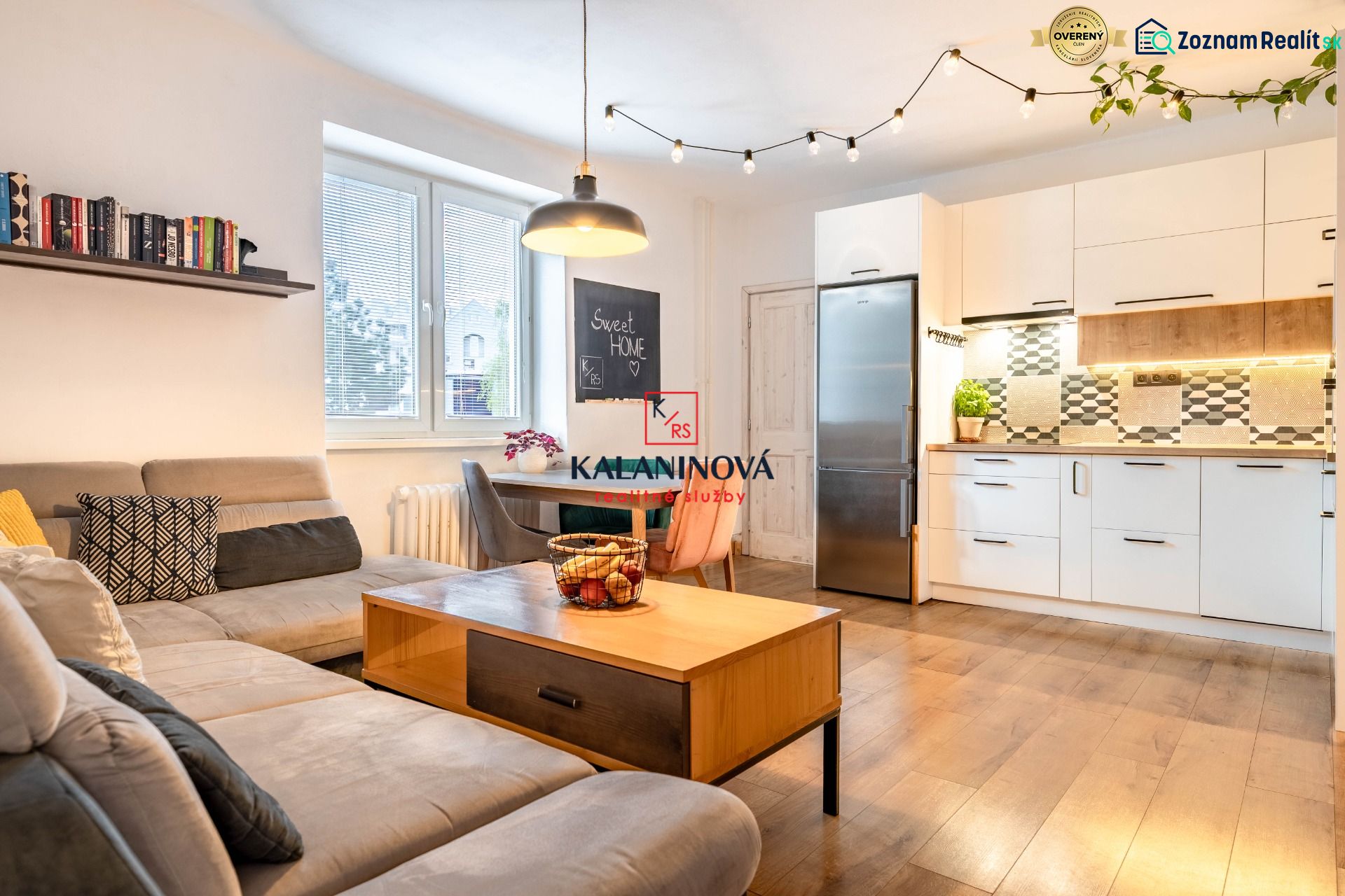 Wohnzimmer mit Küche, Holzboden, Sofa und Esstisch.