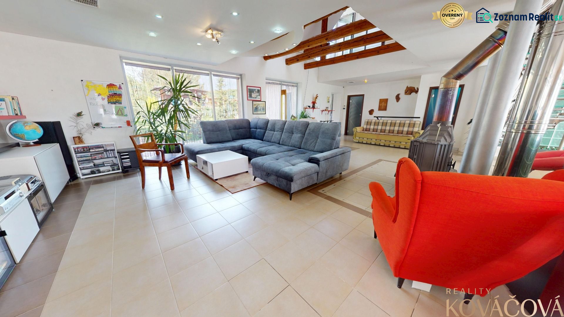 Wohnzimmer in einem Einfamilienhaus mit Kamin, Sofa und Zimmerpflanzen.