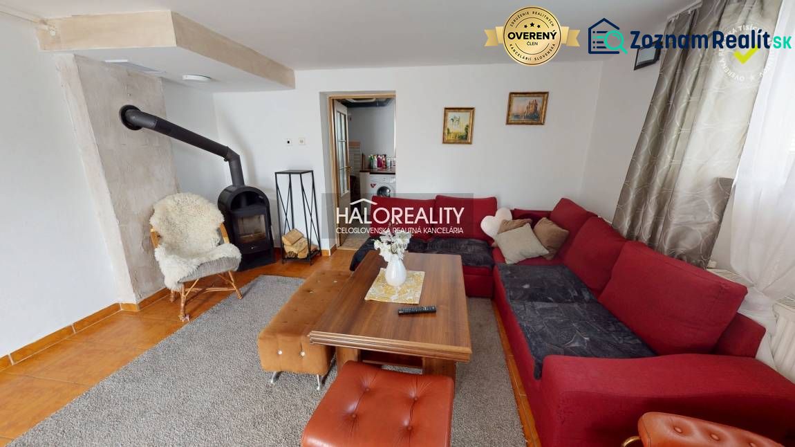 Wohnzimmer in einem Einfamilienhaus mit Kamin, bequemer Couch und Holztisch.