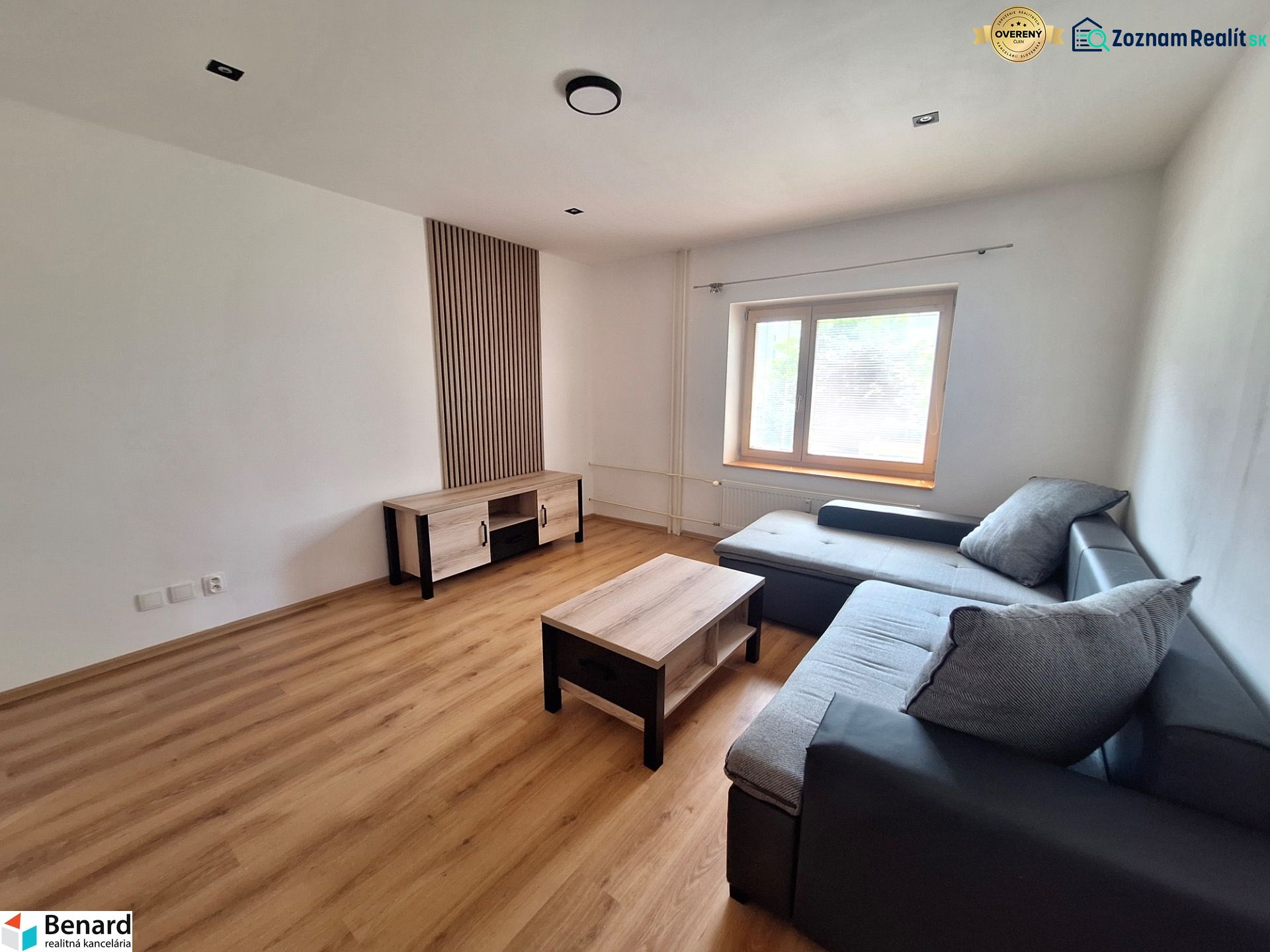 Wohnzimmer mit Ecksofa und Holzmöbeln in einer 2-Zimmer-Wohnung.