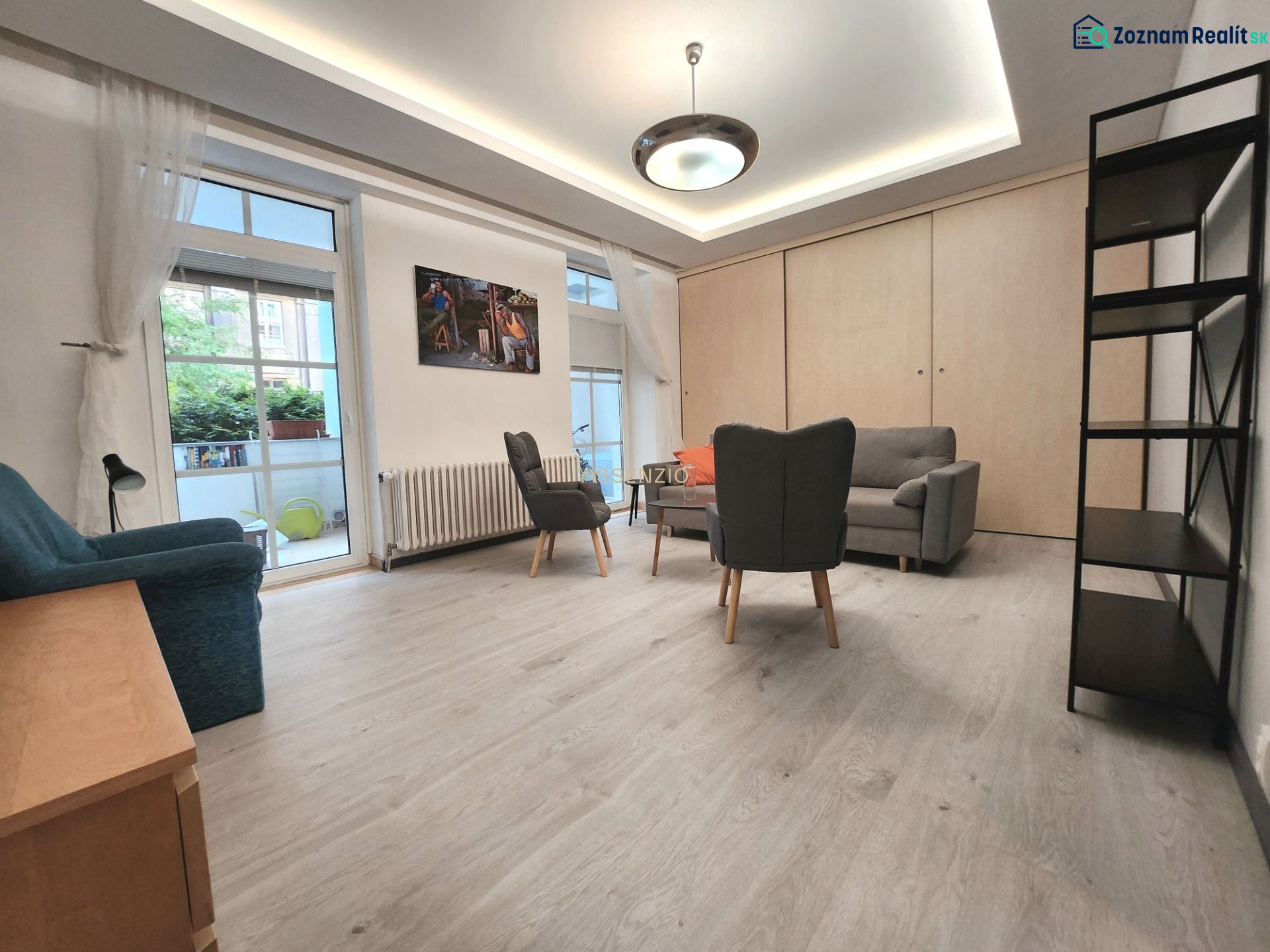 Wohnzimmer in einer 2-Zimmer-Wohnung, Boden mit Holzdekor, Möbel, große Fenster.