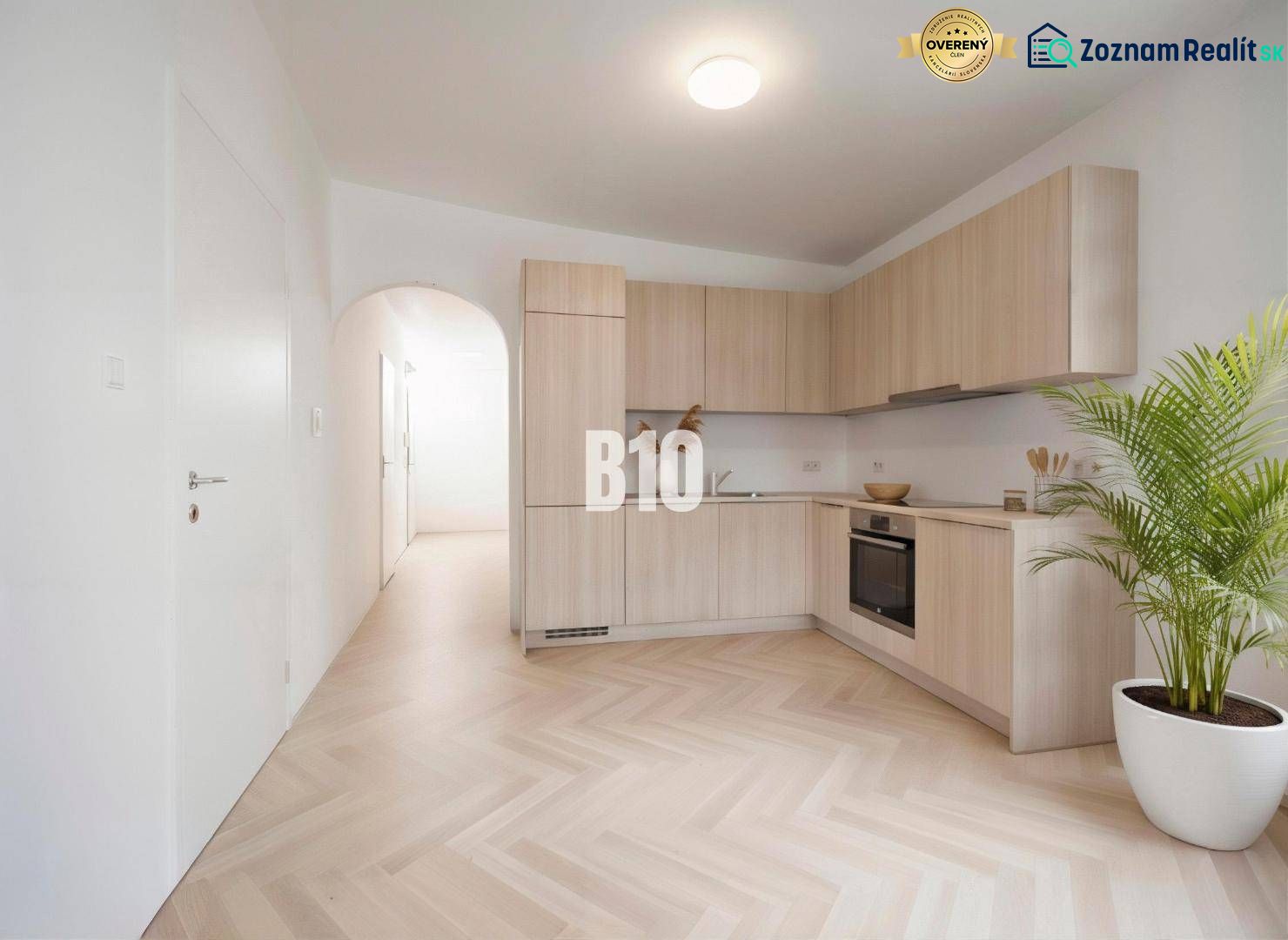Küche in einer 4-Zimmer-Wohnung mit Holzboden und hellen Möbeln.