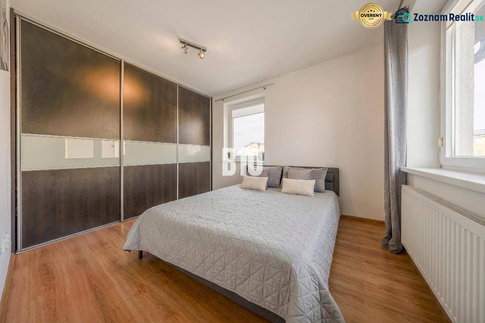 Schlafzimmer in einer 2-Zimmer-Wohnung mit Holzboden und großem Einbauschrank.