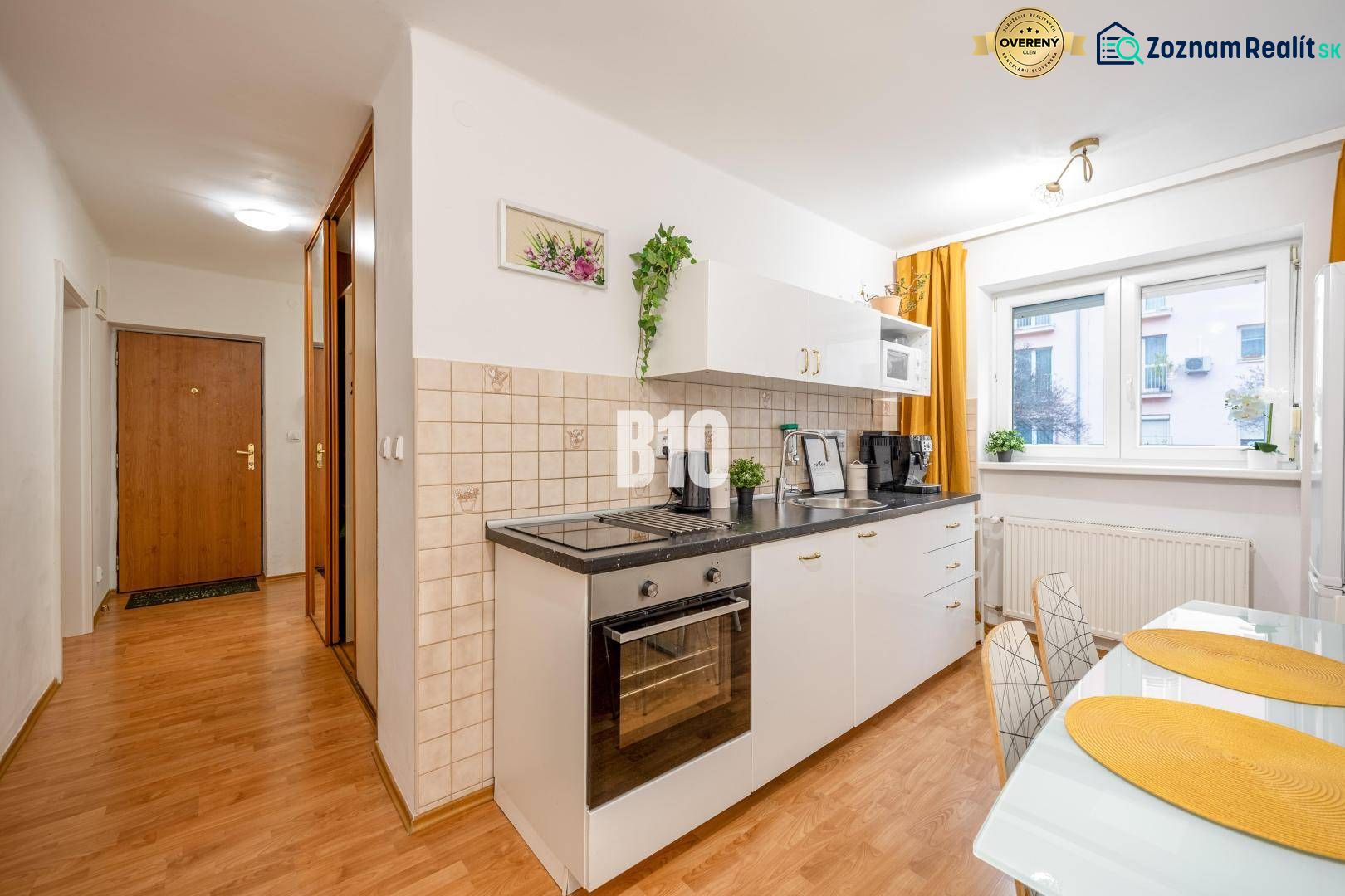 Küche in einer 2-Zimmer-Wohnung mit eingebauten Geräten und einem Bodenbelag in Holzoptik.