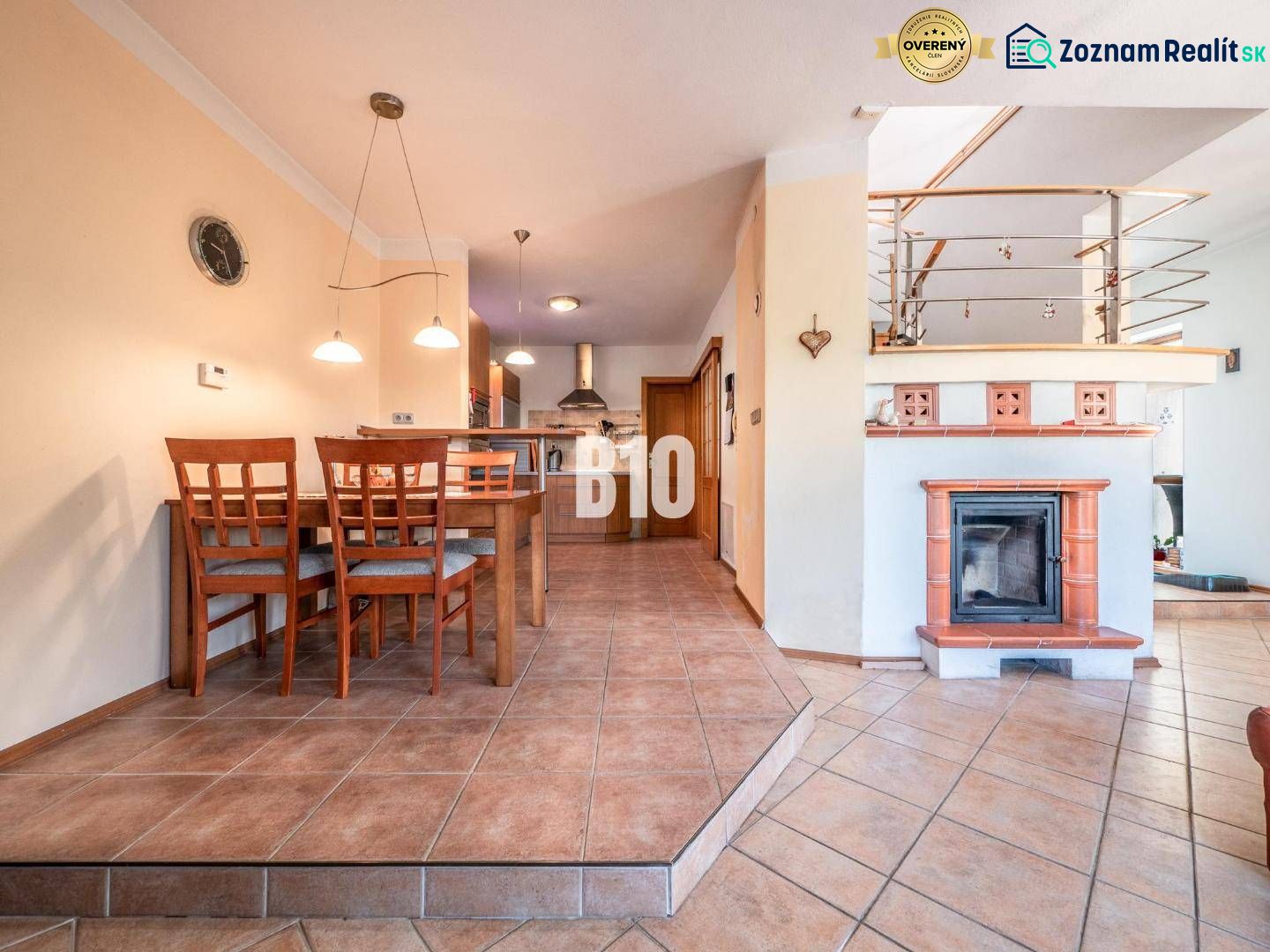 Esszimmer mit Kamin und Küche in einem Einfamilienhaus mit Keramikfliesen.