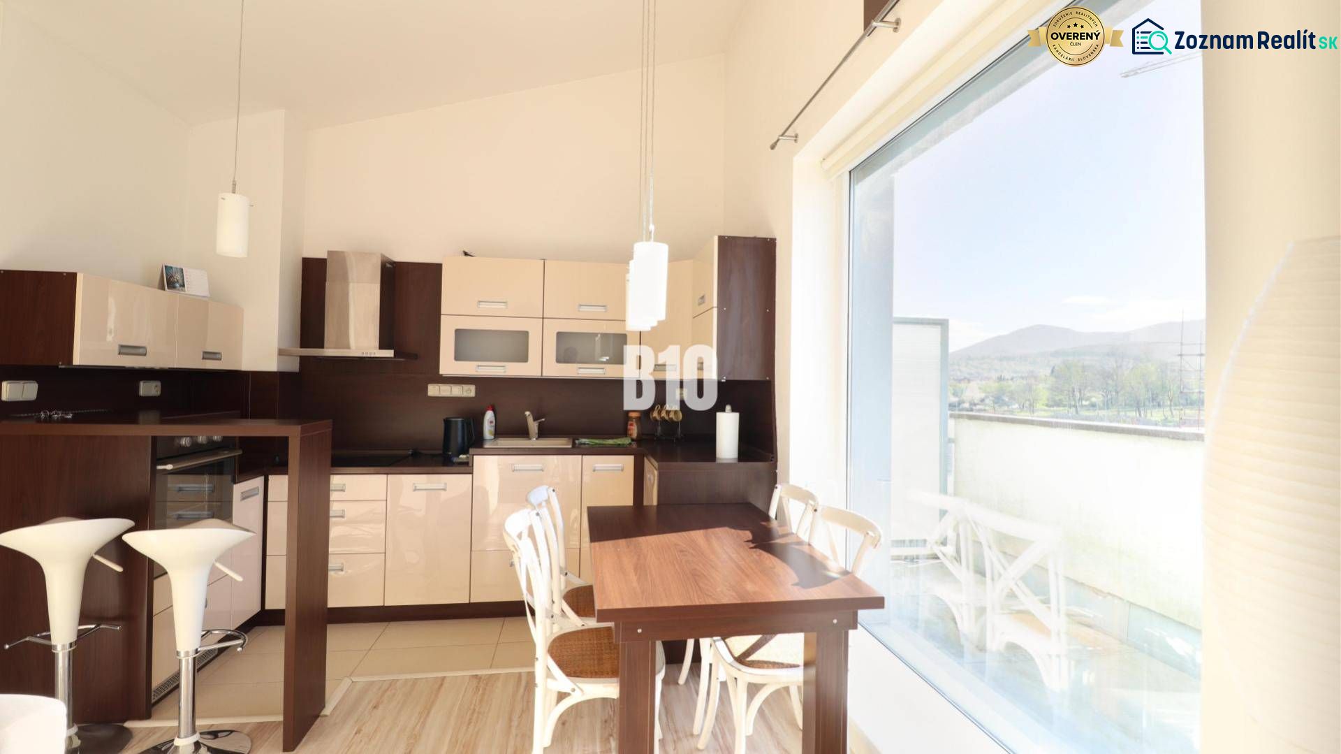 Küche in einer 2-Zimmer-Wohnung mit großem Fenster und Holzboden.