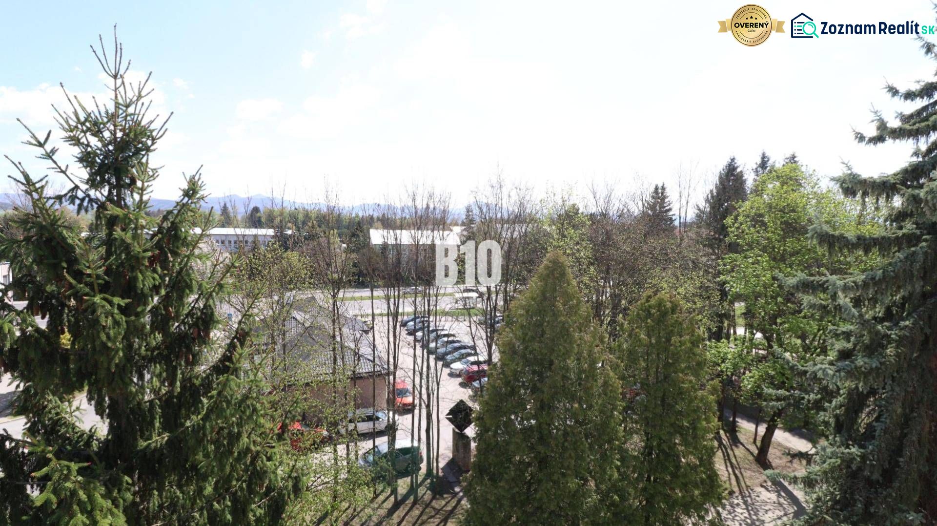 Blick aus einer 3-Zimmer-Wohnung in Martin, mit Aussicht auf Grünflächen und einen Parkplatz.