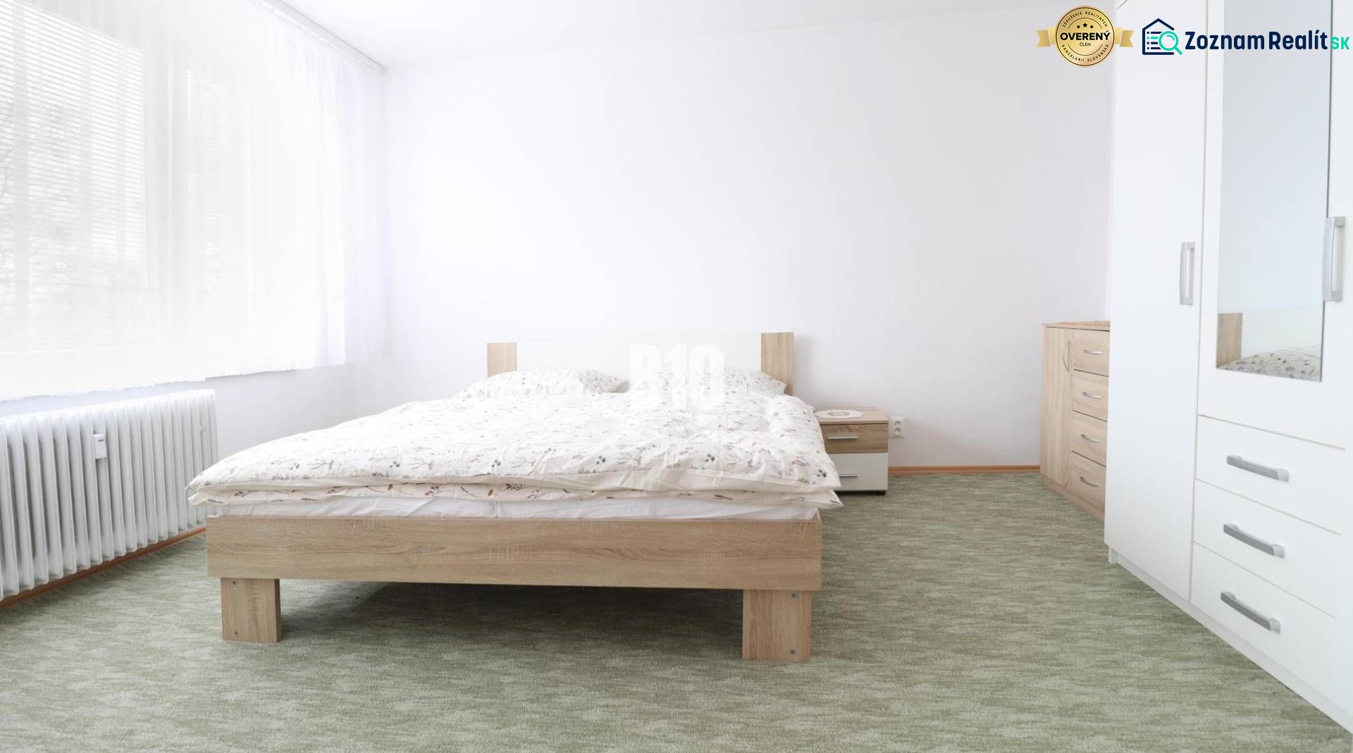 Schlafzimmer in einer 3-Zimmer-Wohnung mit Doppelbett, weißen Möbeln und Teppich.