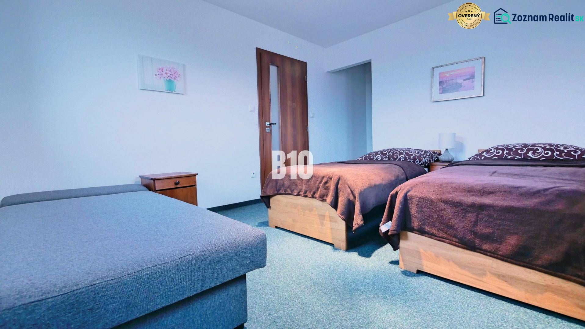 Schlafzimmer in einer 3-Zimmer-Wohnung mit zwei Betten, Nachttischen und einem Sofa.