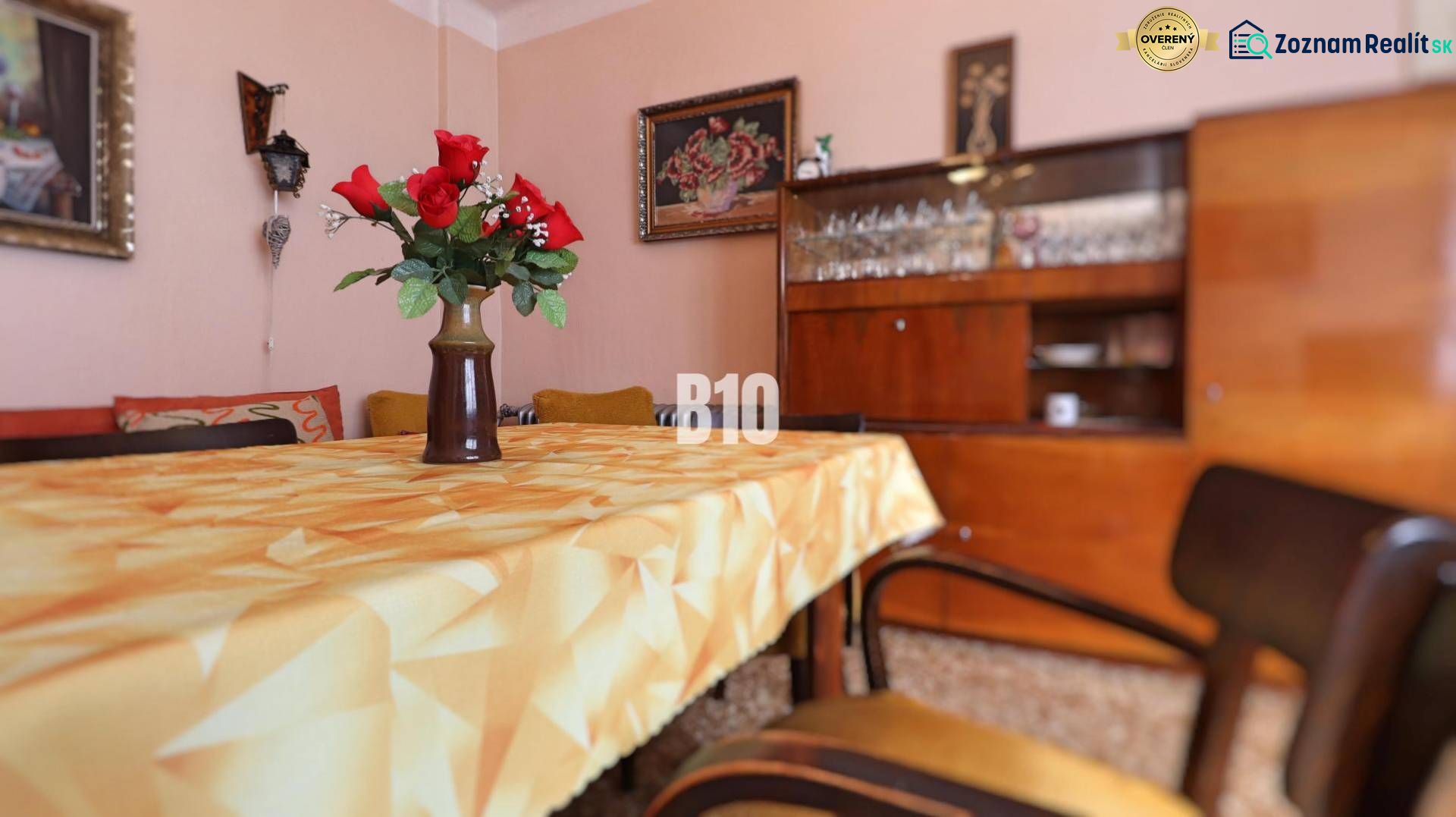Esszimmer in einem Einfamilienhaus mit Blumen auf dem Tisch, Retro-Möbeln und Gläsern im Schrank.