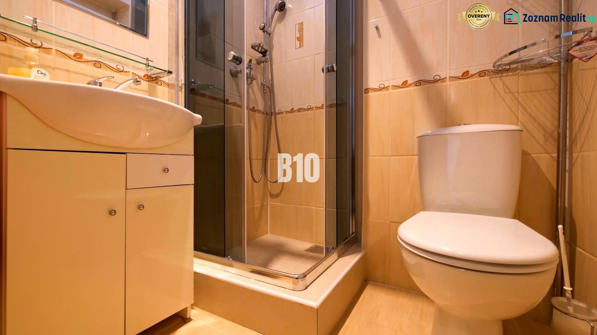 Badezimmer in einer Einzimmerwohnung mit Dusche, Waschbecken und Toilette.