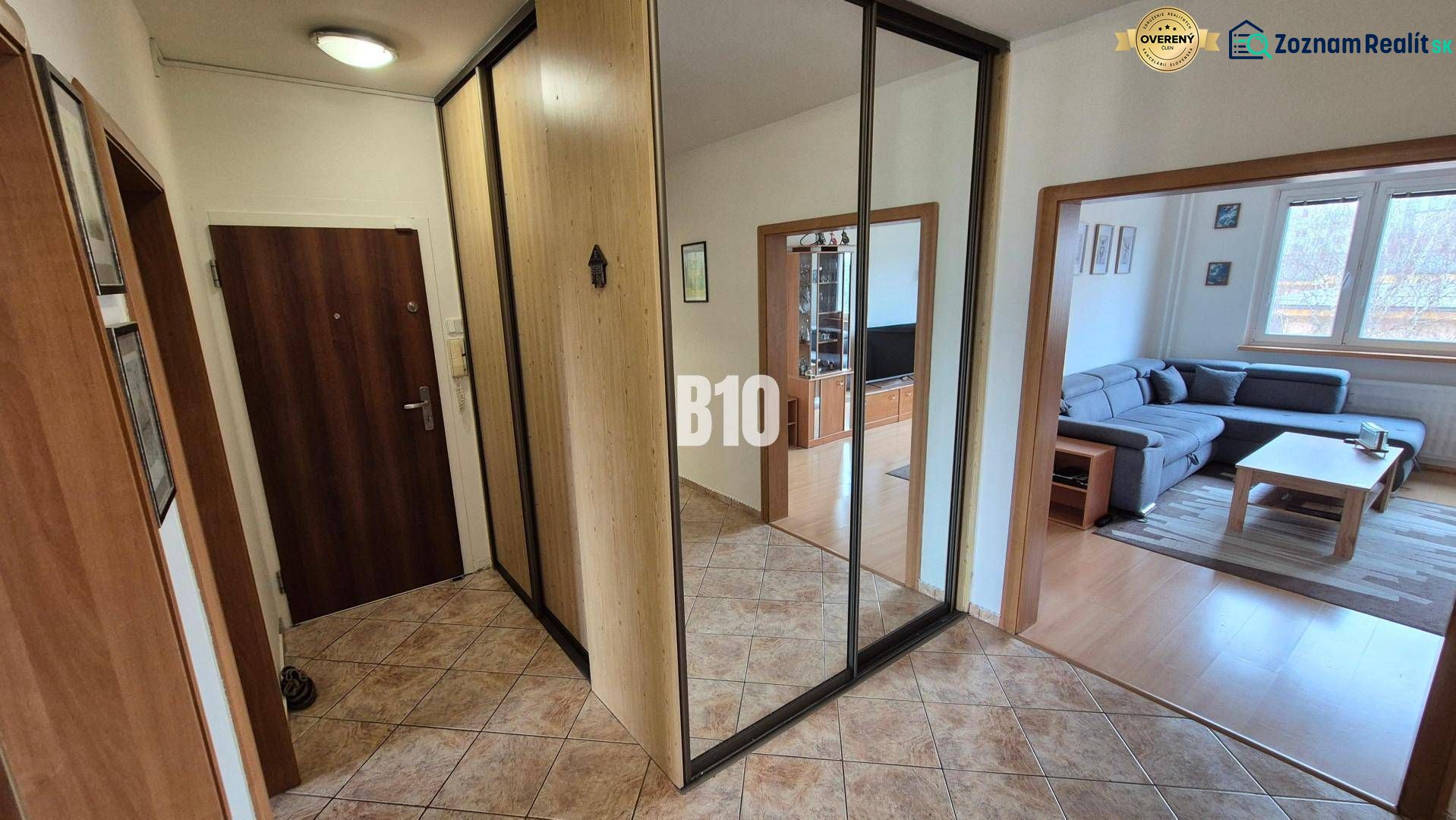 In einer Wohnung mit 5 oder mehr Zimmern, Böden mit Holzdekor, Spiegel und Sofa im Wohnzimmer.