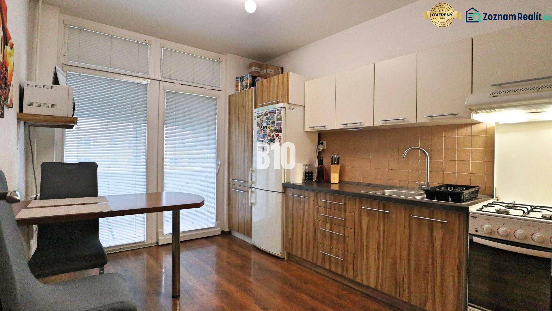 Küche in einer 4-Zimmer-Wohnung mit Holzboden und Essecke.