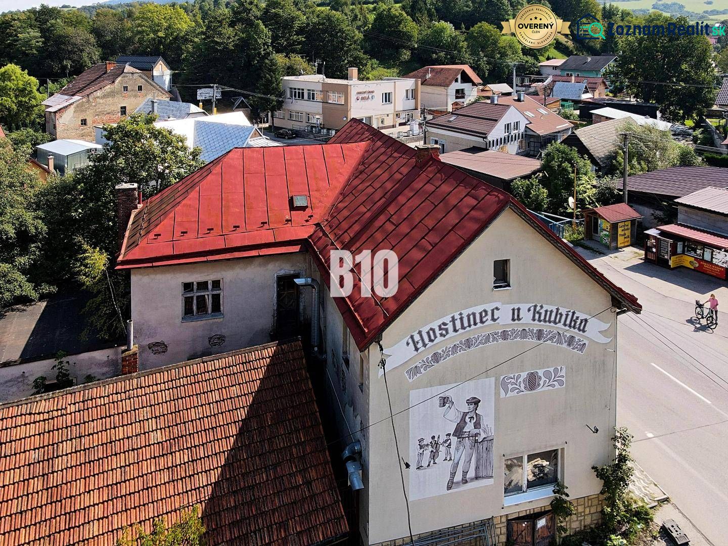 Gasthaus in Belej mit rotem Dach und Wandgemälde eines Mannes mit Bier.