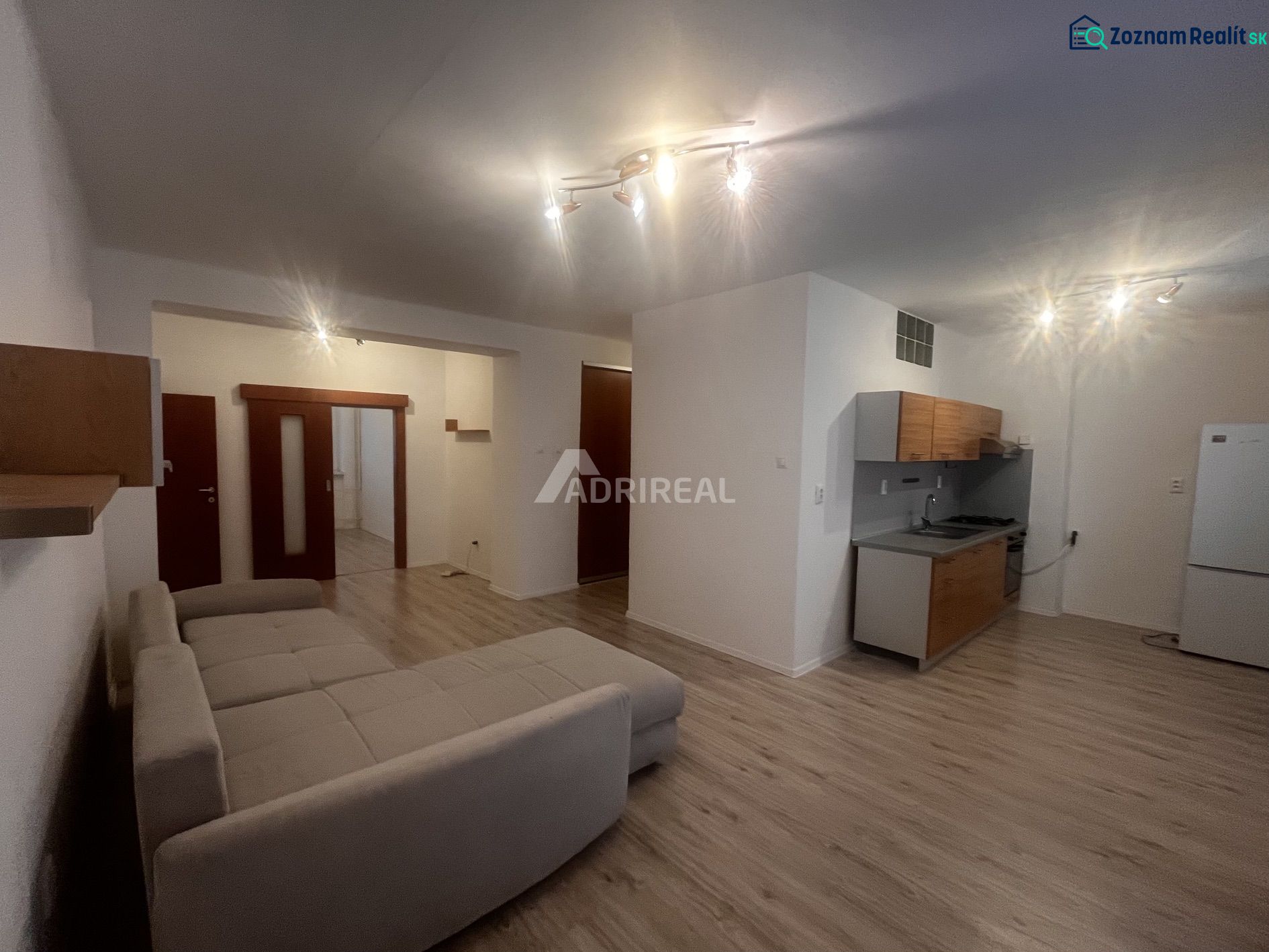 Wohnzimmer in einer 3-Zimmer-Wohnung mit Küche und Holzboden.