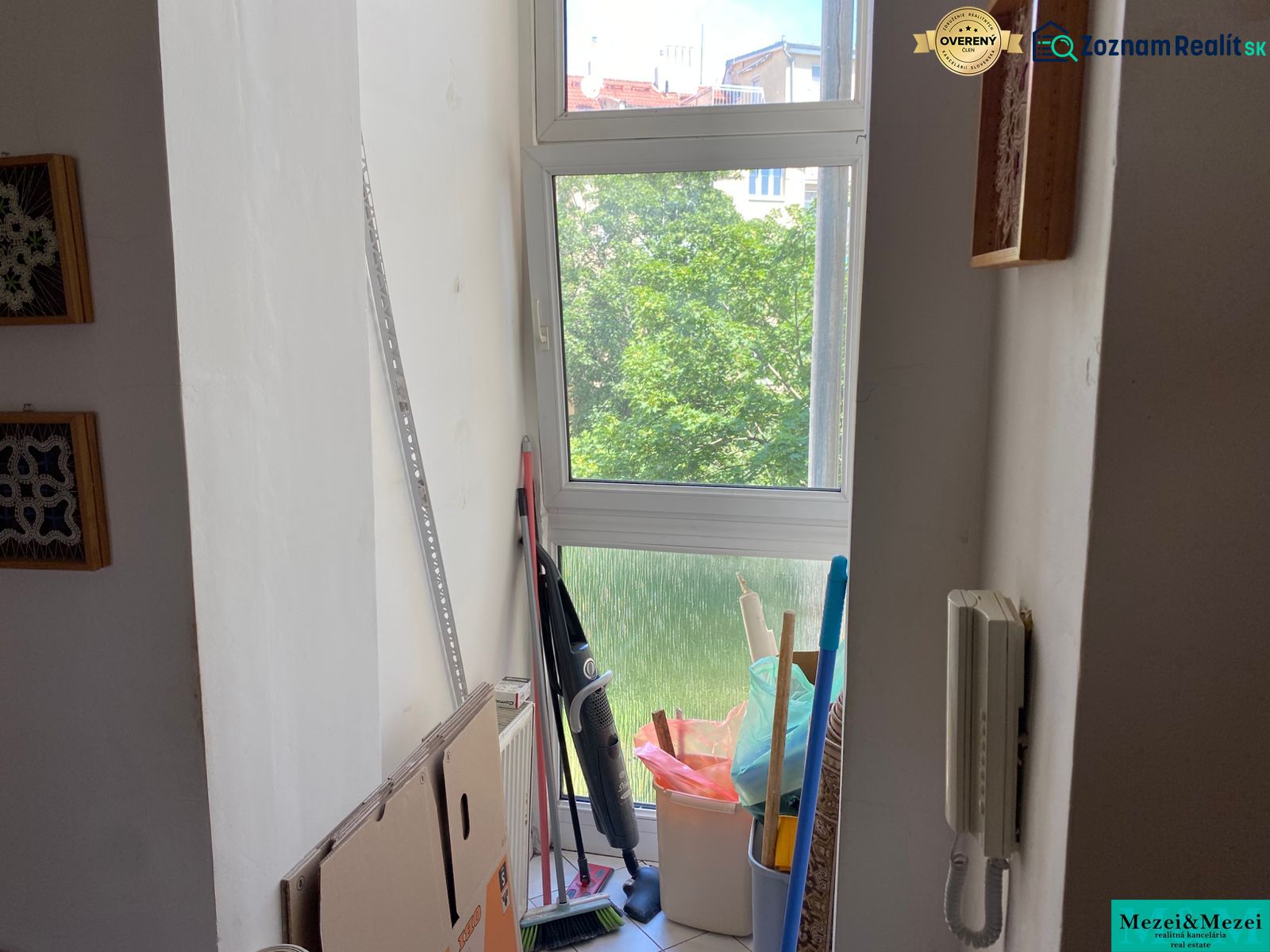 Fensterteil einer 2-Zimmer-Wohnung mit Kartons, Reinigungsmitteln und Gegensprechanlage.