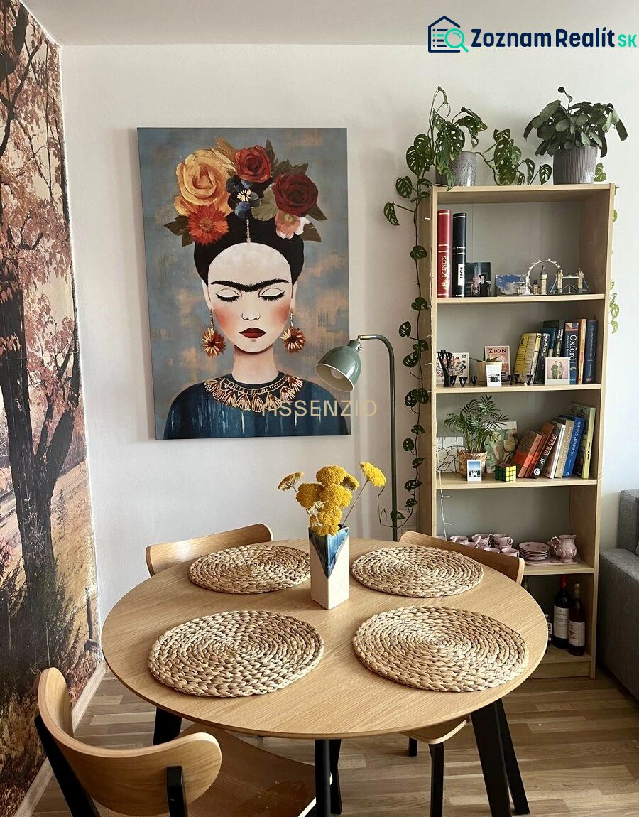 Esszimmer in einer 2-Zimmer-Wohnung mit einem Bild, einem Holztisch und dekorativen Accessoires.