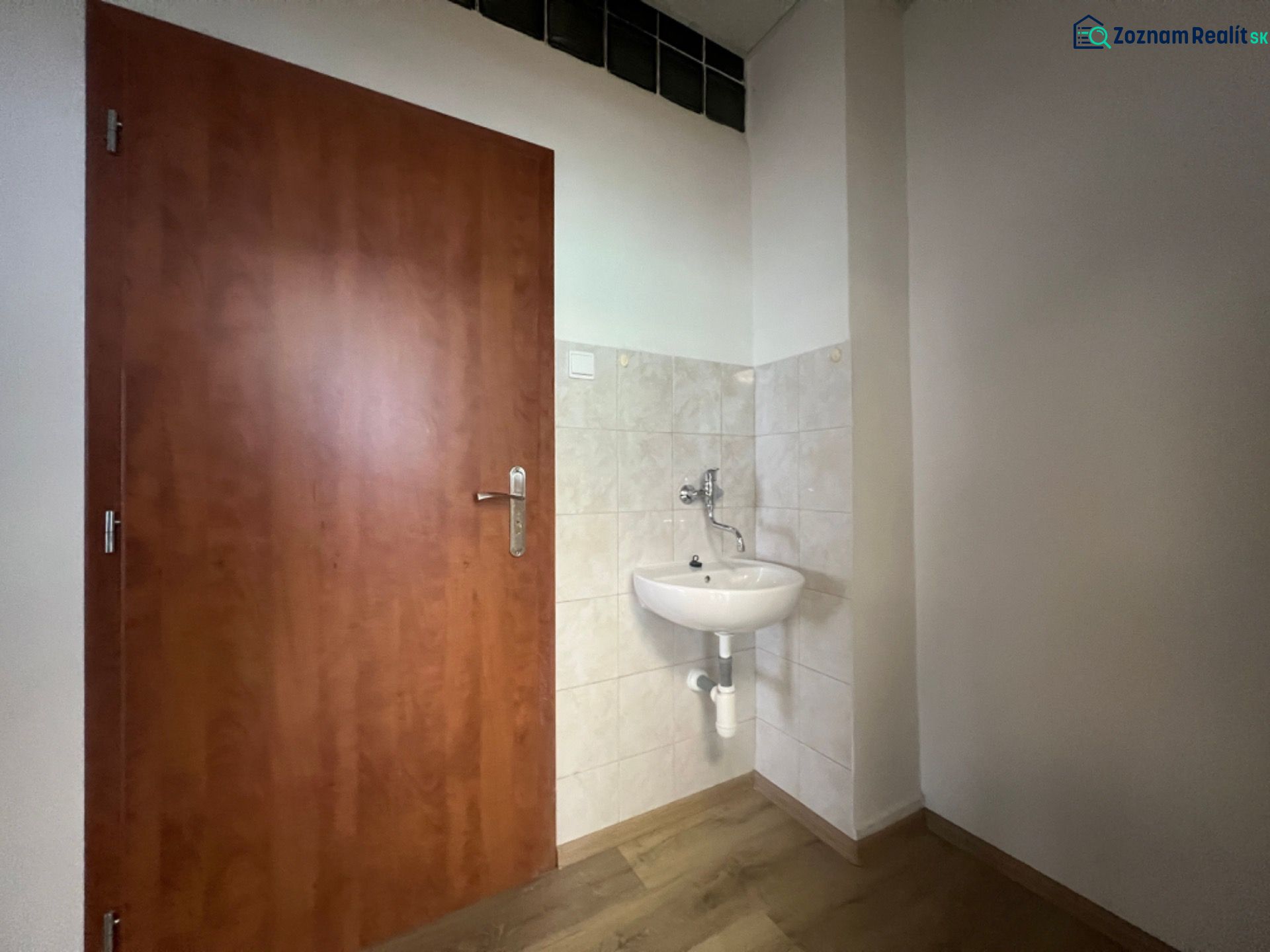 Büros mit Waschbecken, Türen und Boden in Holzoptik.