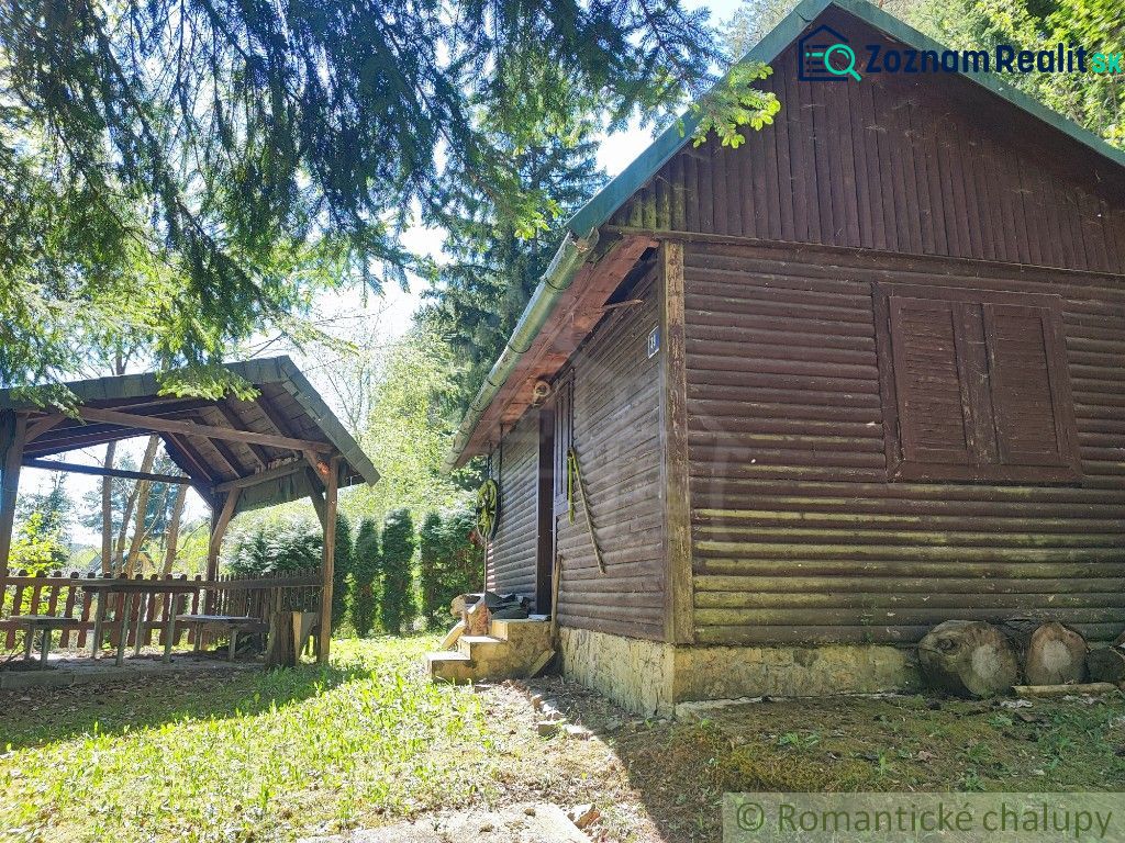 Eine Hütte in Slovenská Ľupča, umgeben von Grün, mit einer Außensitzgelegenheit und Holzelementen.