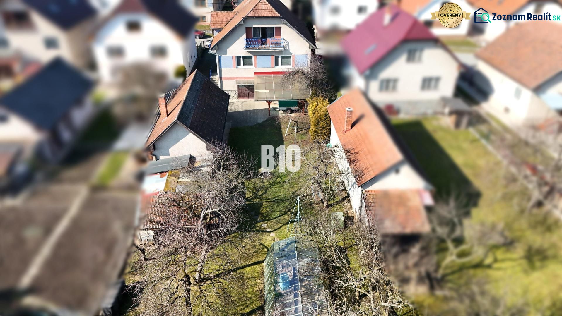 Ein Einfamilienhaus in Turany mit einem großen Hof und Anbauten, umgeben von einem Garten.