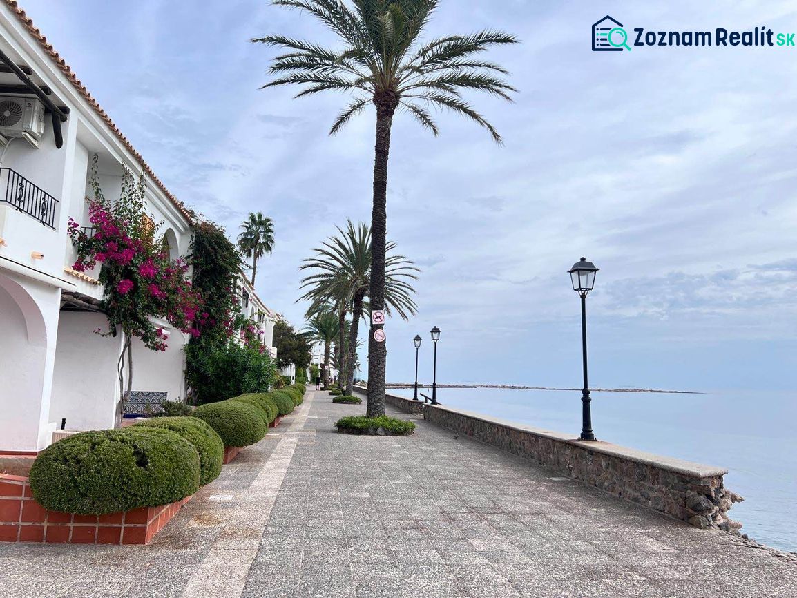 Die Strandpromenade in La Manga del Mar Menor, Spanien, gesäumt von Palmen und Lampen.