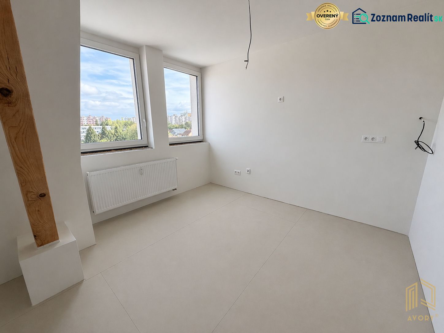 Ein Zimmer einer 2-Zimmer-Wohnung mit großen Fenstern und einem Boden in Holzoptik.