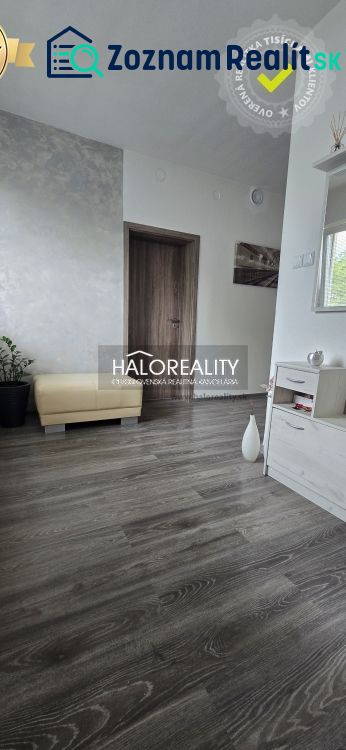 Ein Zimmer in einem Einfamilienhaus mit einem Boden in Holzoptik und moderner Einrichtung.