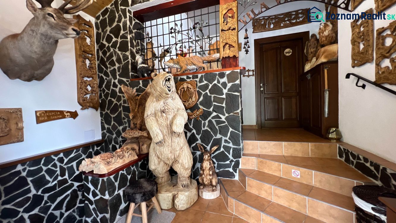 Interieur der Villa mit hölzernen Tierskulpturen und Steinwänden.