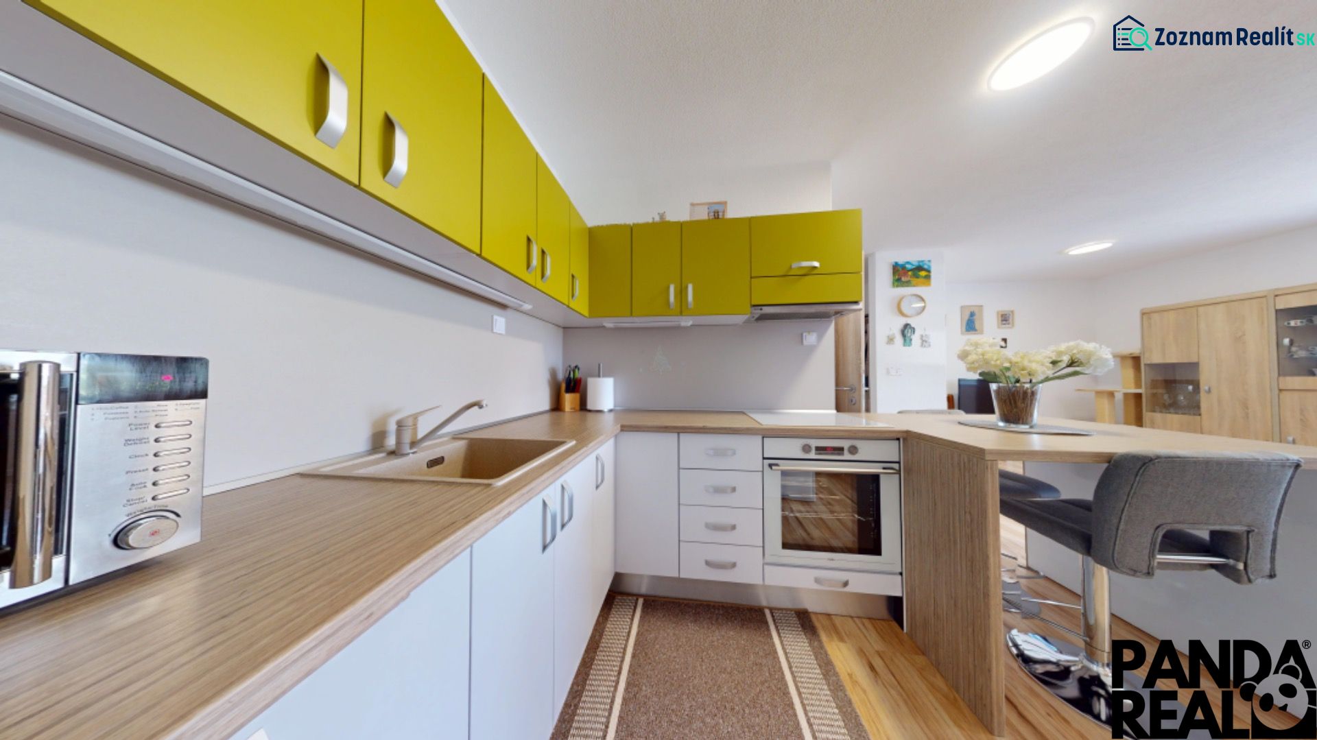 Küche mit bunten Schränken und Holzboden in einer 3-Zimmer-Wohnung.