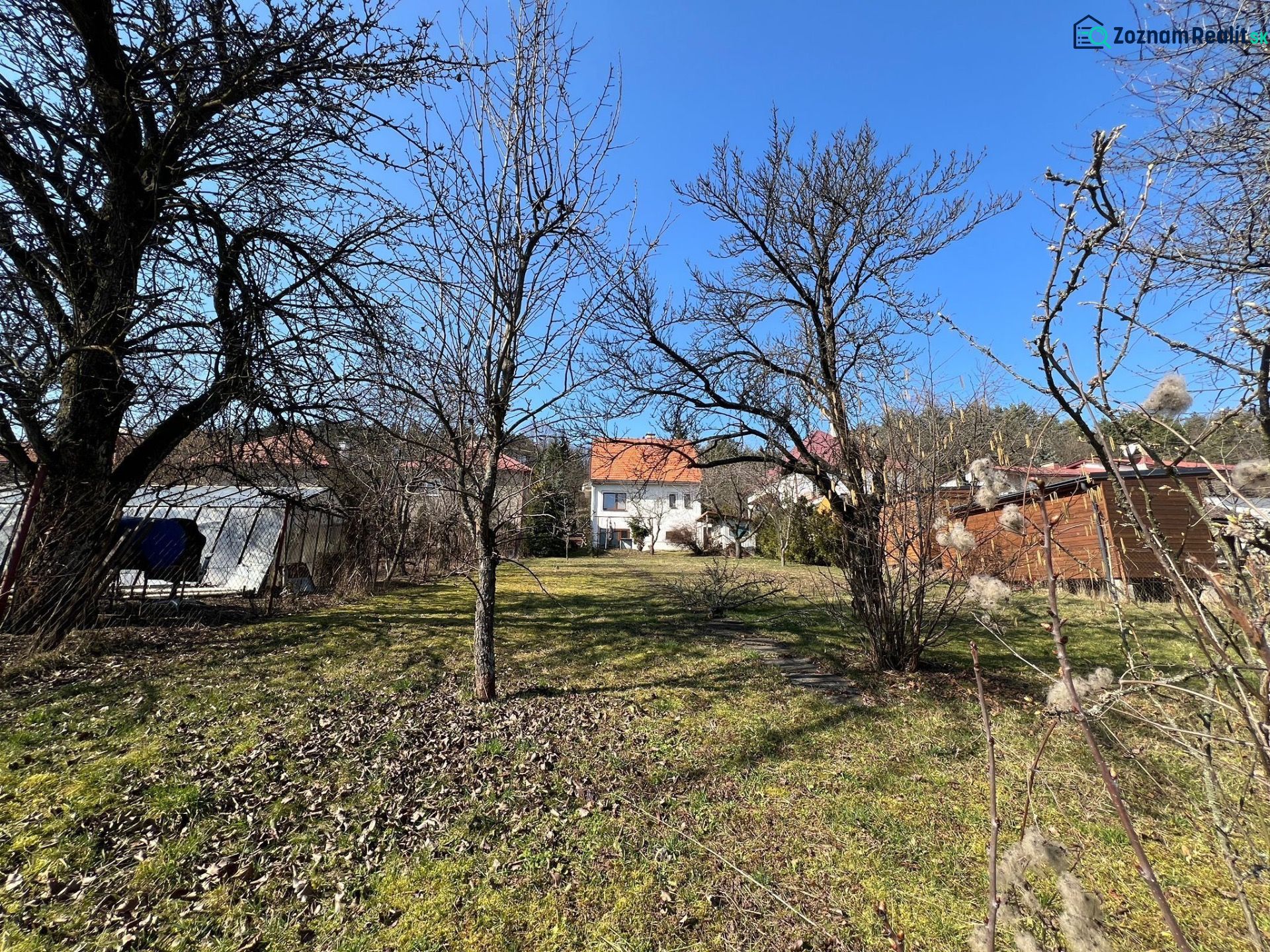 Ein Garten im Bezirk Banská Bystrica rund um ein Einfamilienhaus mit Rasen und Bäumen.