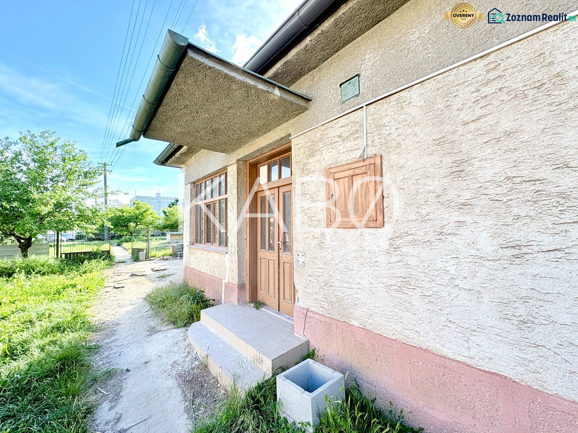 Ein Einfamilienhaus in Šoporňa mit einem Außeneingang und einem grünen Vorgarten.