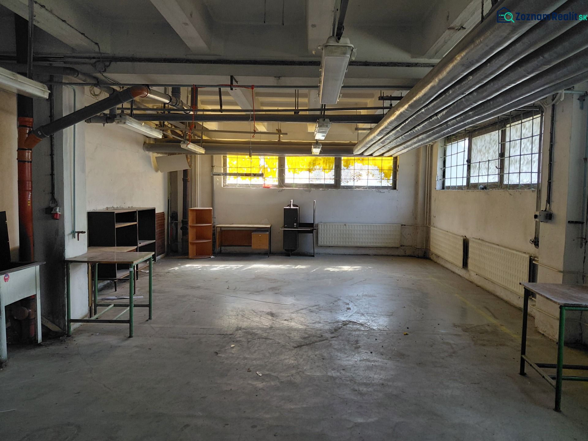Industrielles Interieur mit Rohrleitungen und alter Ausrüstung in Lager und Halle.