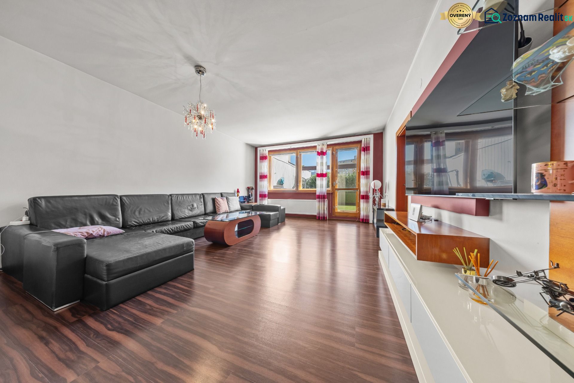Wohnzimmer in einem Einfamilienhaus mit großem Sofa und Holzboden.
