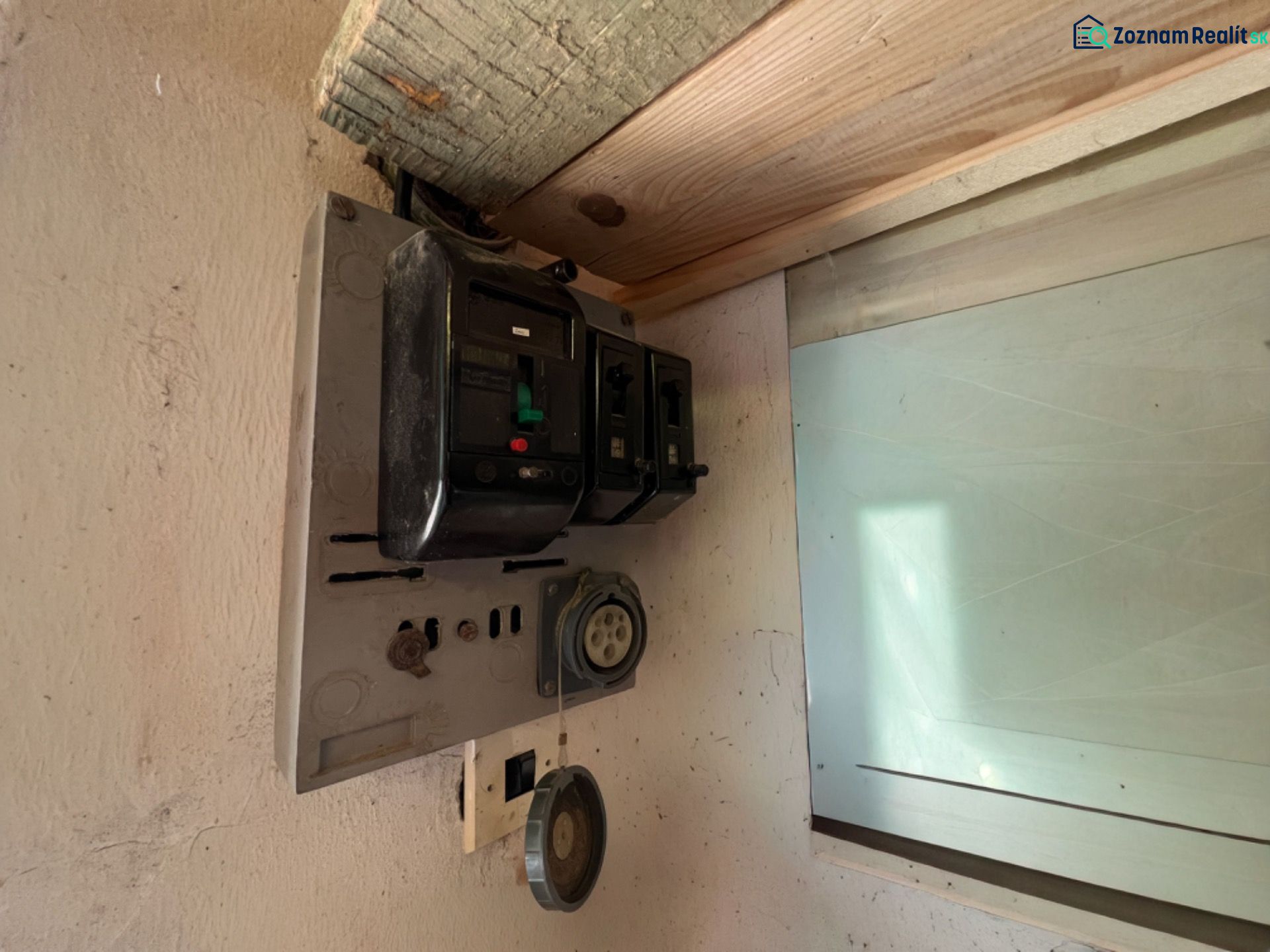 Alter elektrischer Verteilerkasten in der Garage, mit alten Sicherungen und Steckdosen.