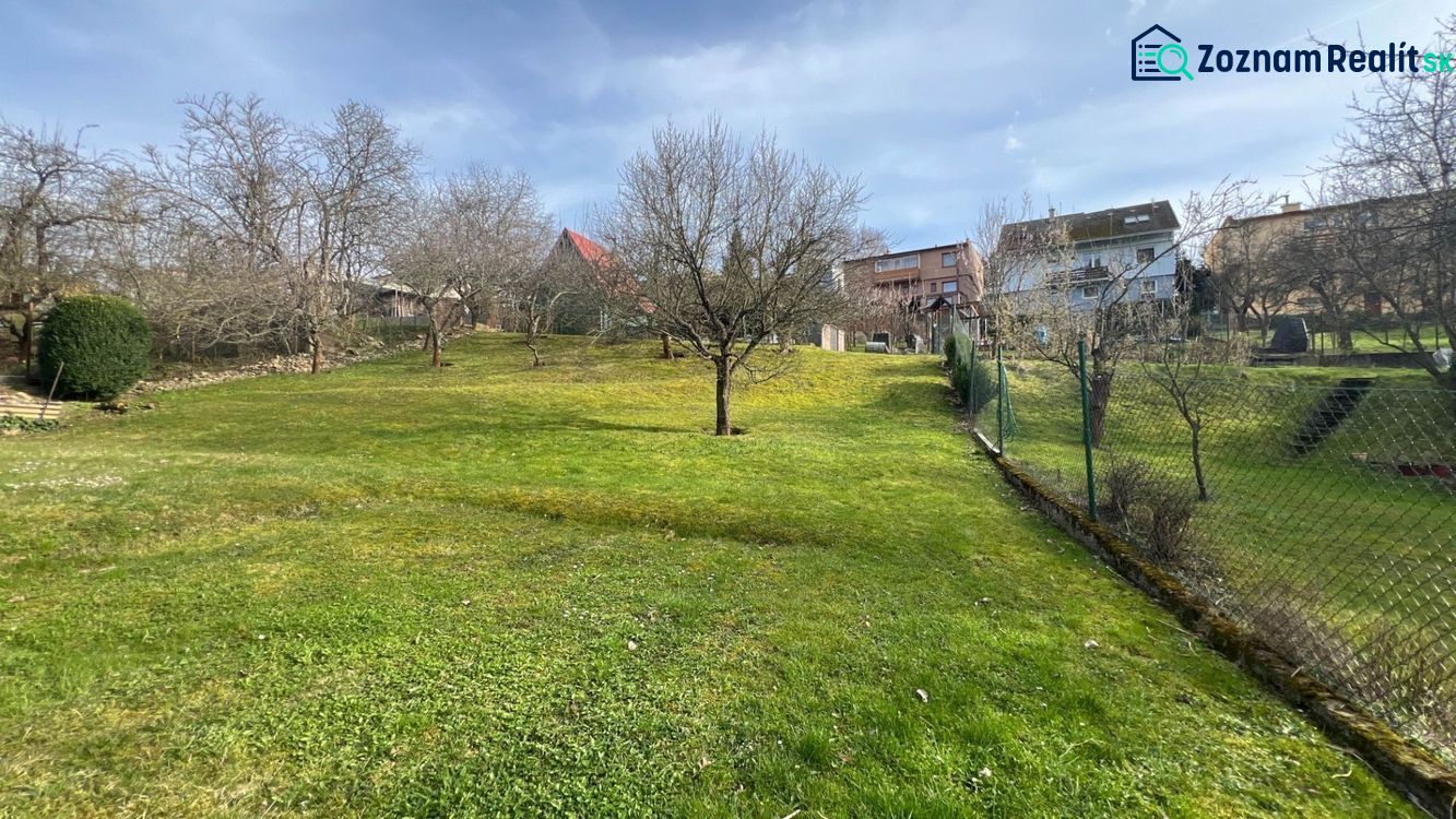 Der Garten des Einfamilienhauses in der Makovického-Straße in Ružomberok mit Bäumen und Rasen.