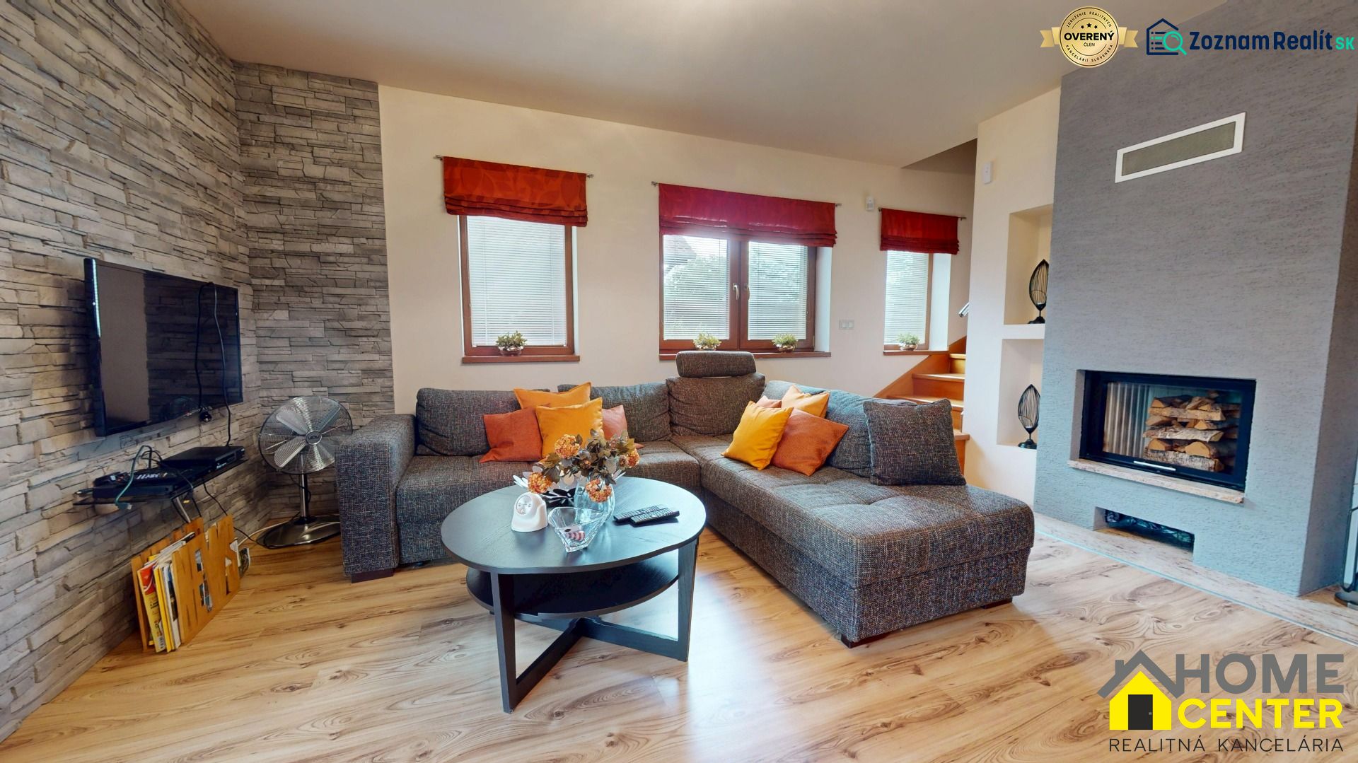 Wohnzimmer in einer Hütte mit Kamin, bequemer Couch und Boden mit Holzdekor.