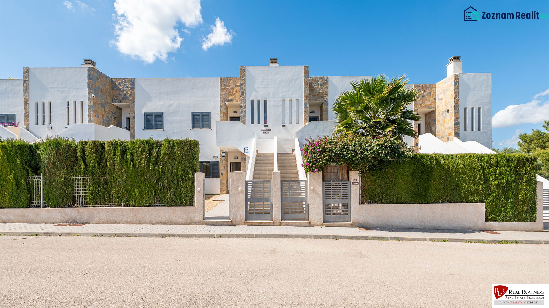 Ferienwohnung in Cala Murada auf Mallorca mit moderner Fassade und grünem Zaun.