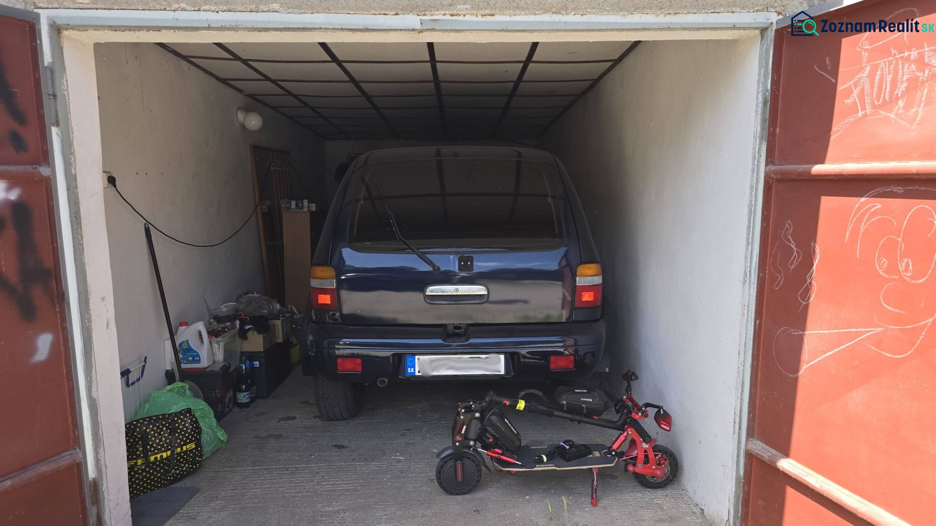 Garage mit Auto und Elektroroller, gelagerten Gegenständen und Zeichnung an der Tür.