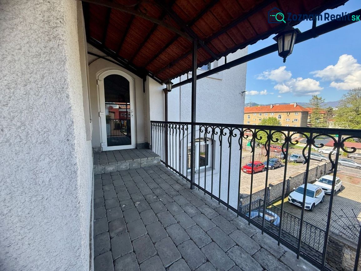 Ein Balkon mit einem Eisengeländer und Blick auf einen Parkplatz in Banská Bystrica. Ungewöhnliche Immobilien.