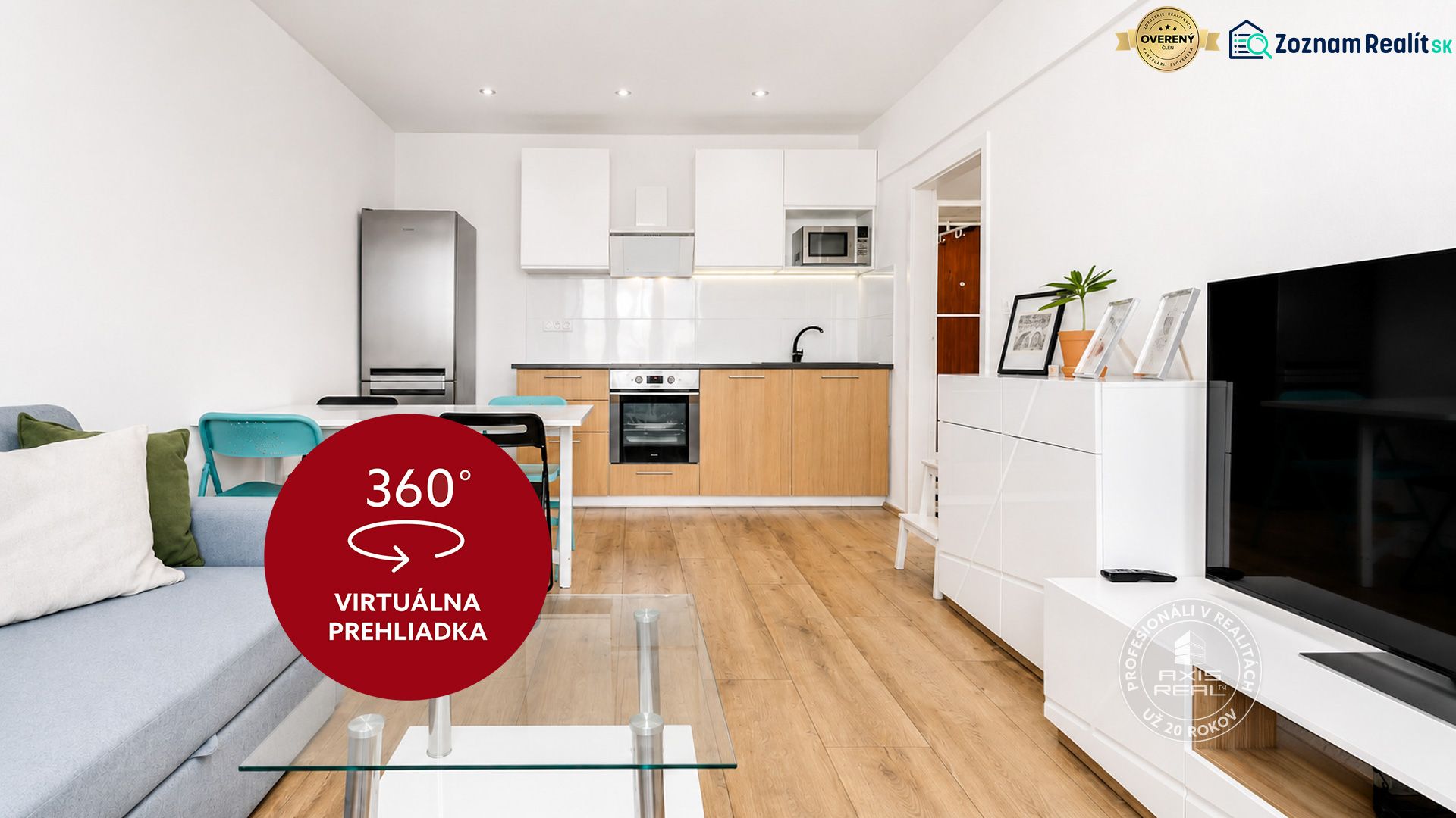 Wohnzimmer mit Küche in einer 2-Zimmer-Wohnung mit Holzboden und grauem Sofa.