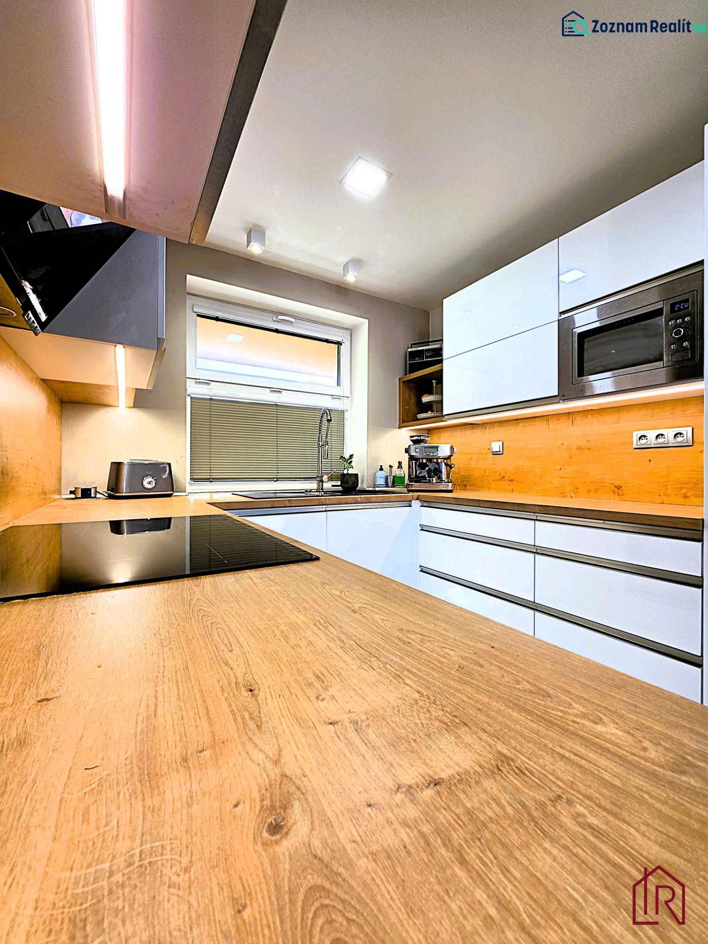Küche mit weißen Schränken und Holzboden in einer 3-Zimmer-Wohnung.